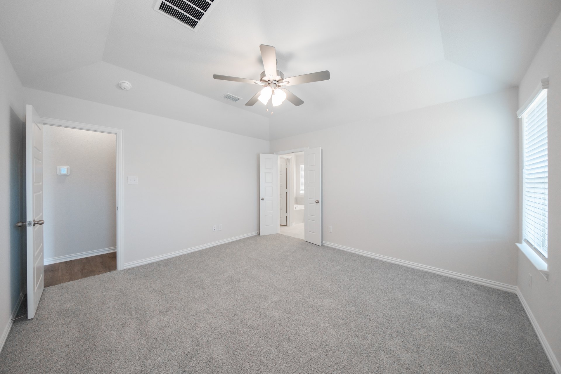 primary bedroom with carpet and windows
