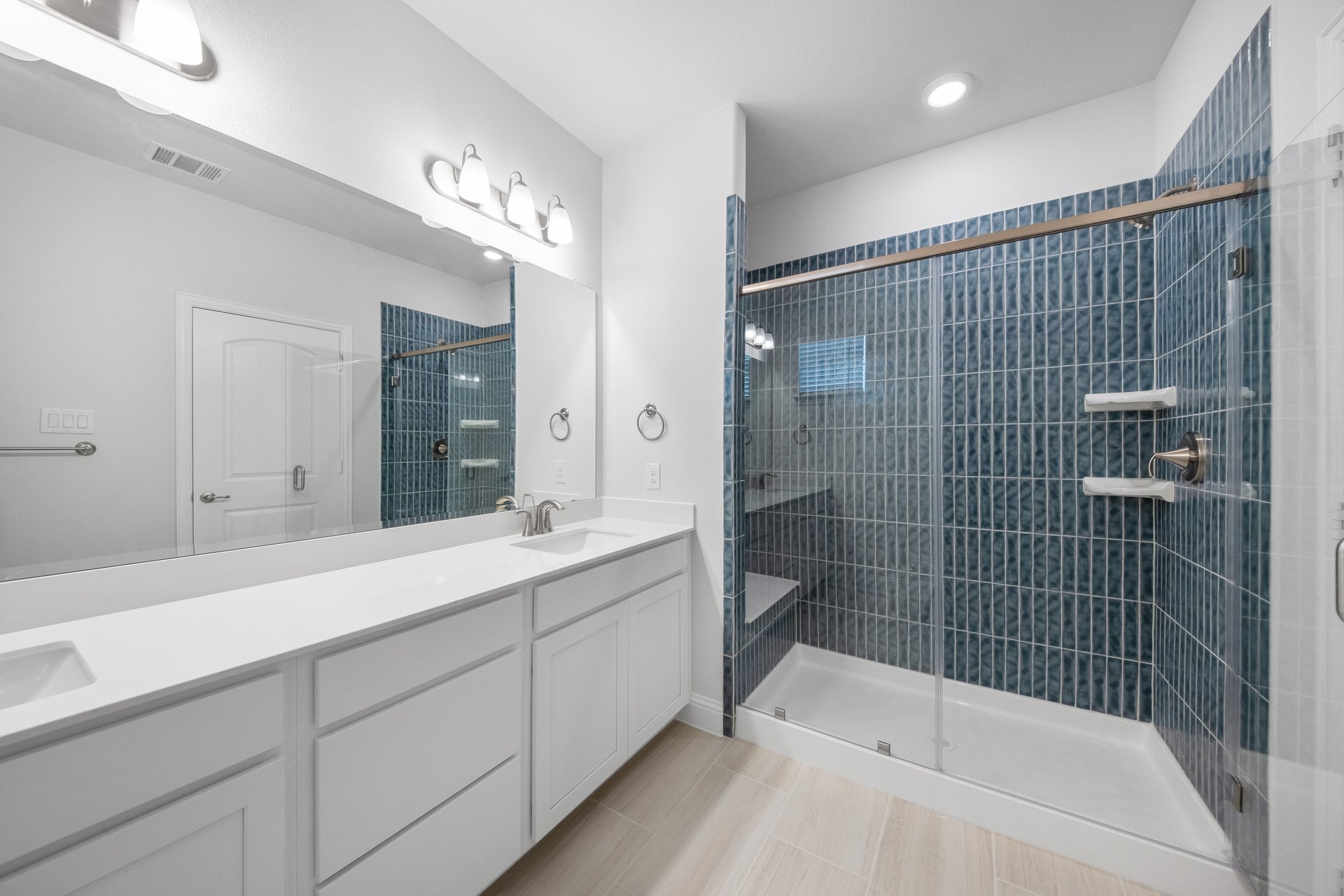 bathroom with walk-in shower and white cabinets