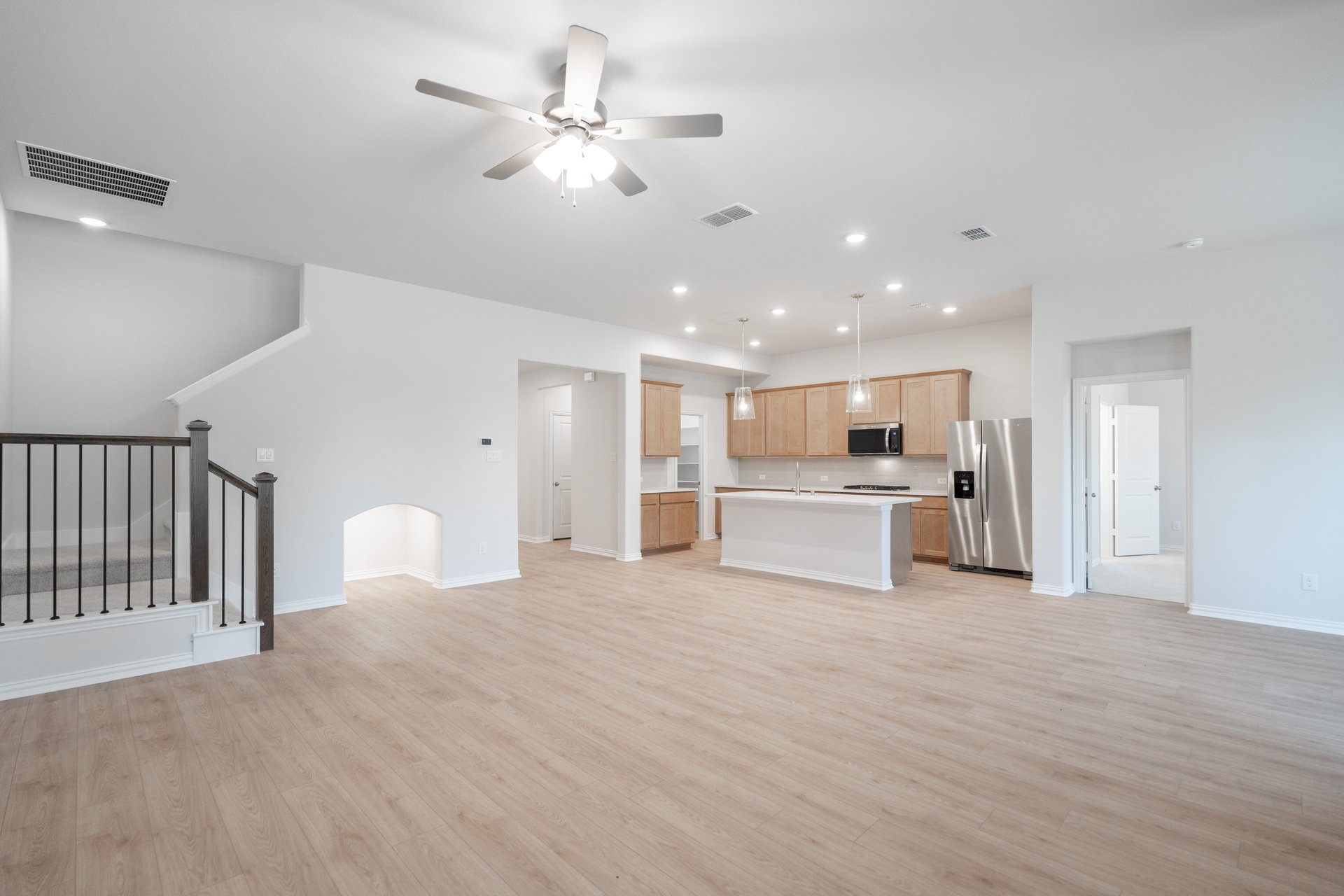 open great room with wood floors and ceiling fan