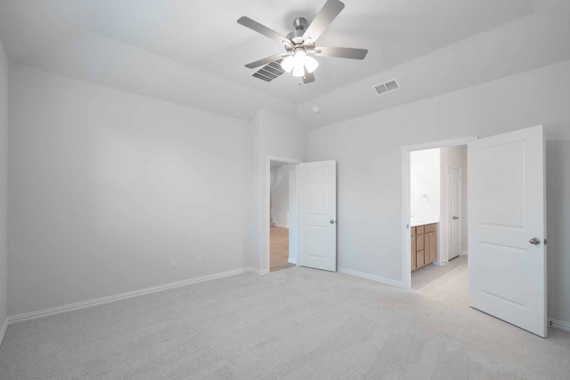 primary bedroom with carpet and ceiling fan