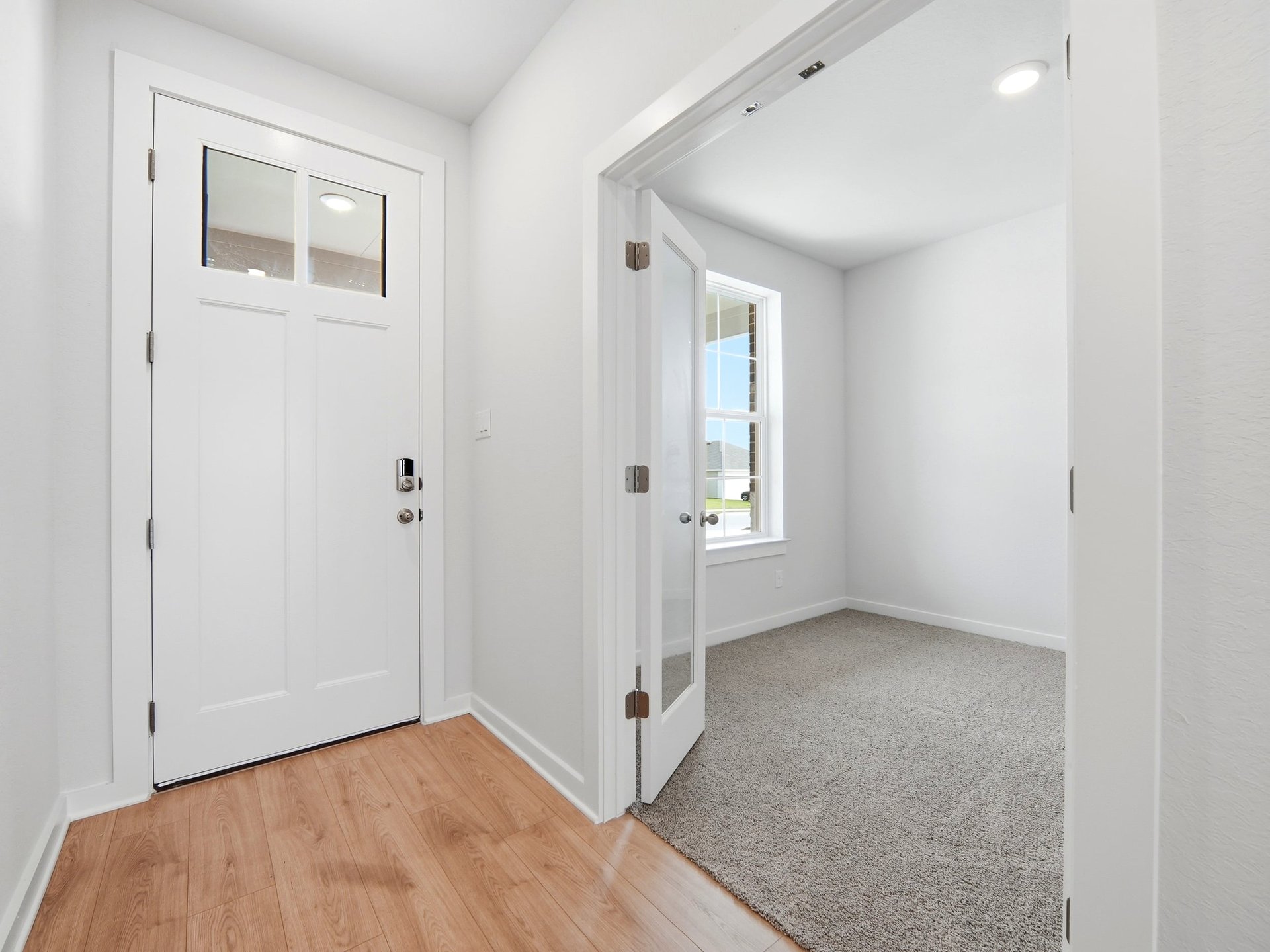 foyer with brown flooring and white door