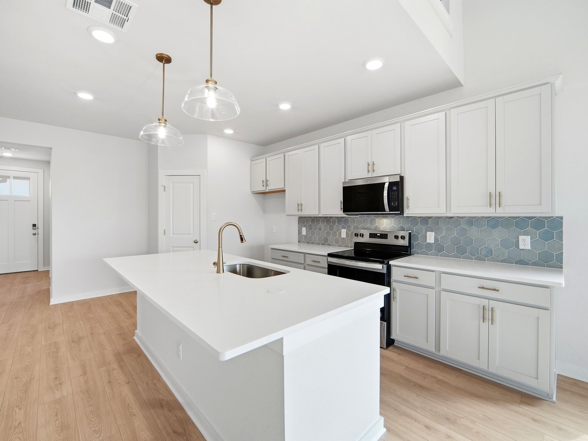 kitchen with white cabinets, brown flooring, pendant lighting
