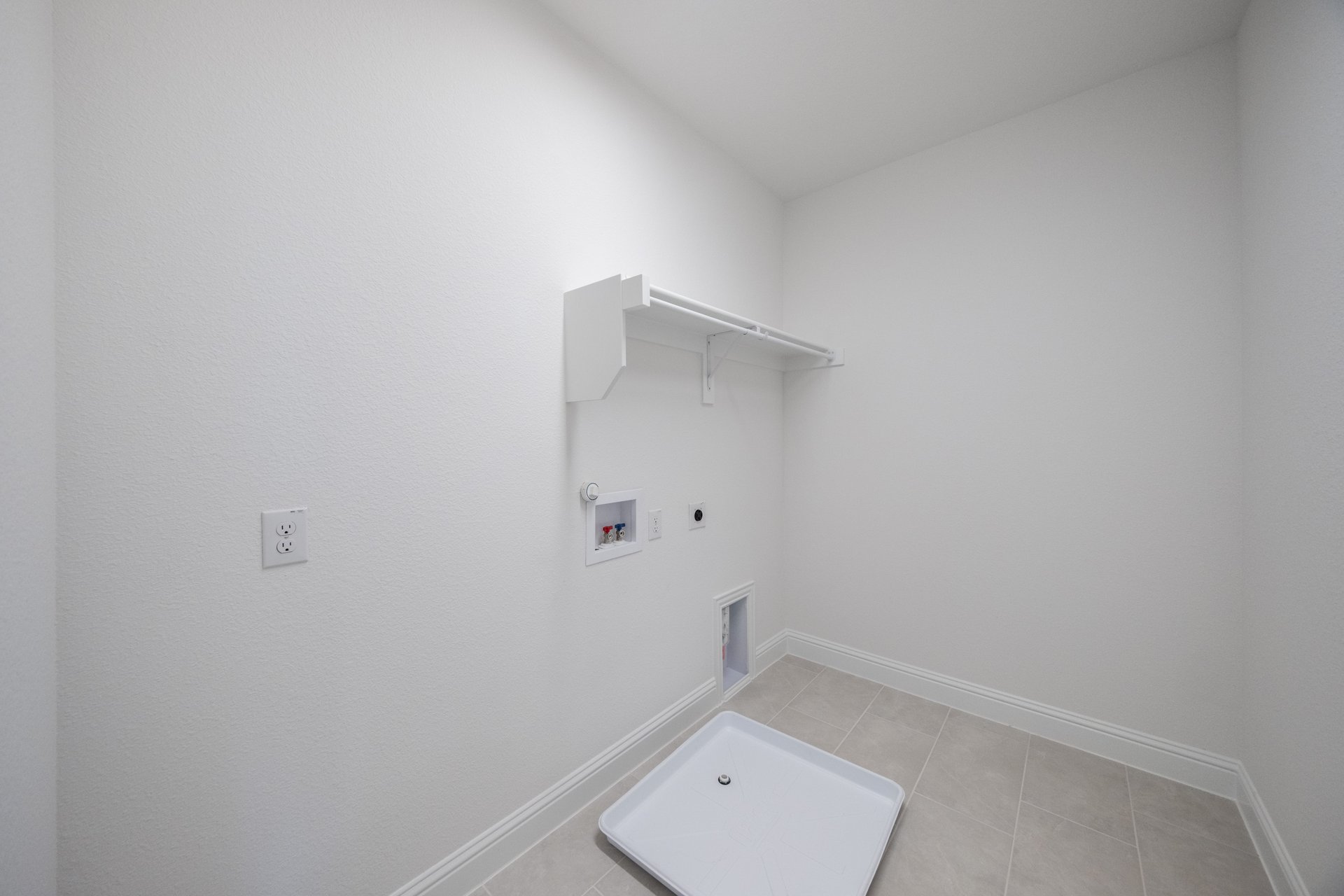 laundry room with tile floors and white shelf