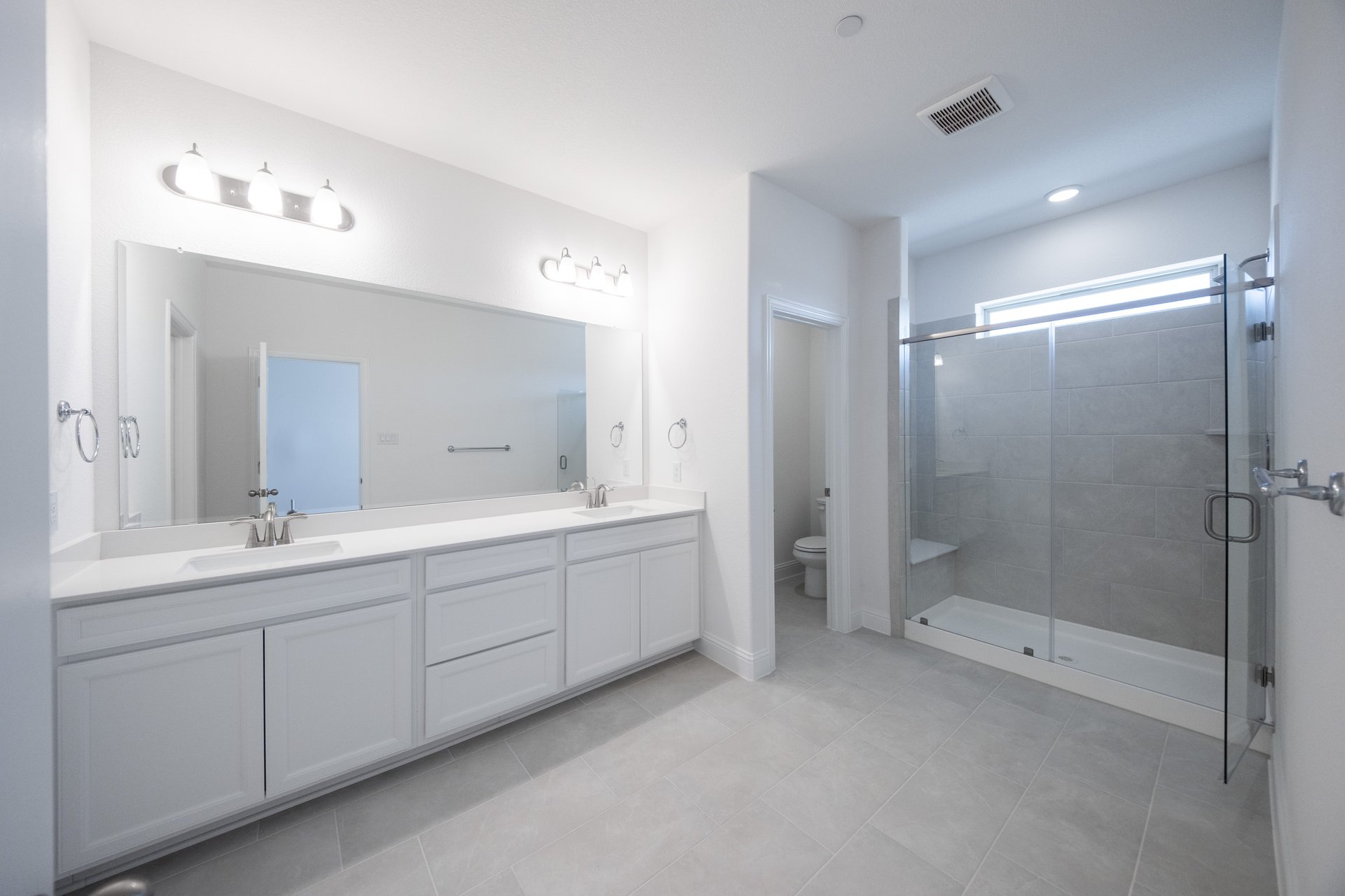 primary bathroom with walk-in shower and tile floors