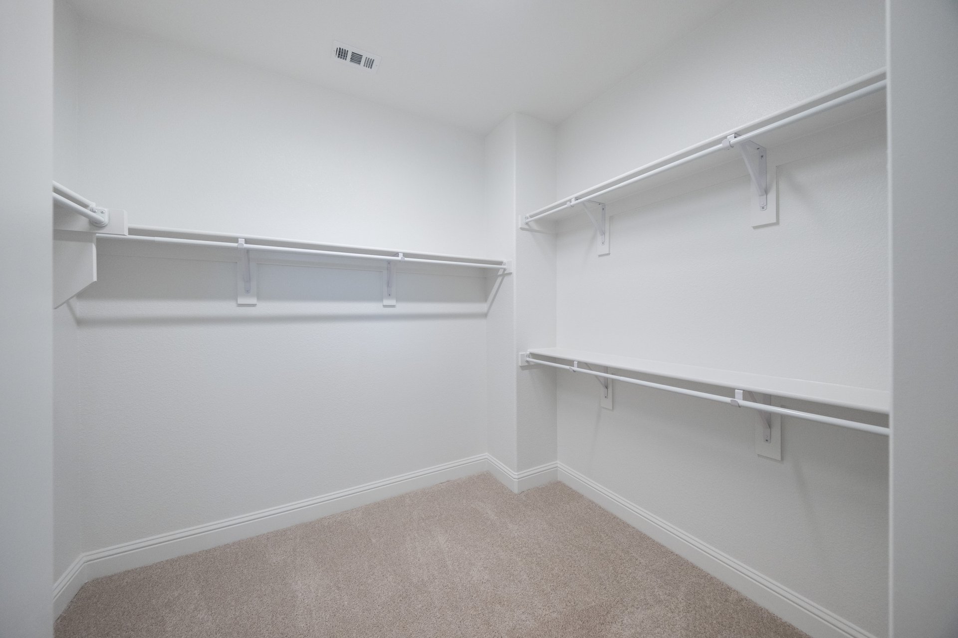 primary bedroom closet with carpet and white shelves