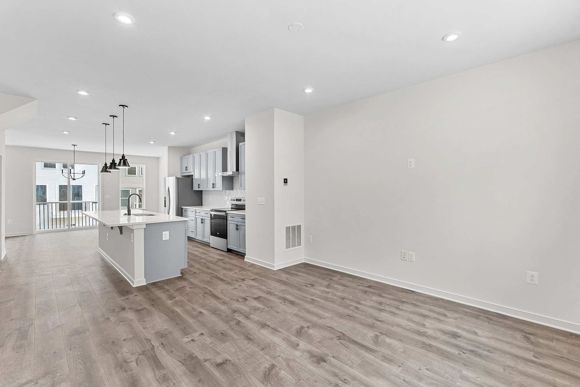 great room with solid flooring and access to the kitchen