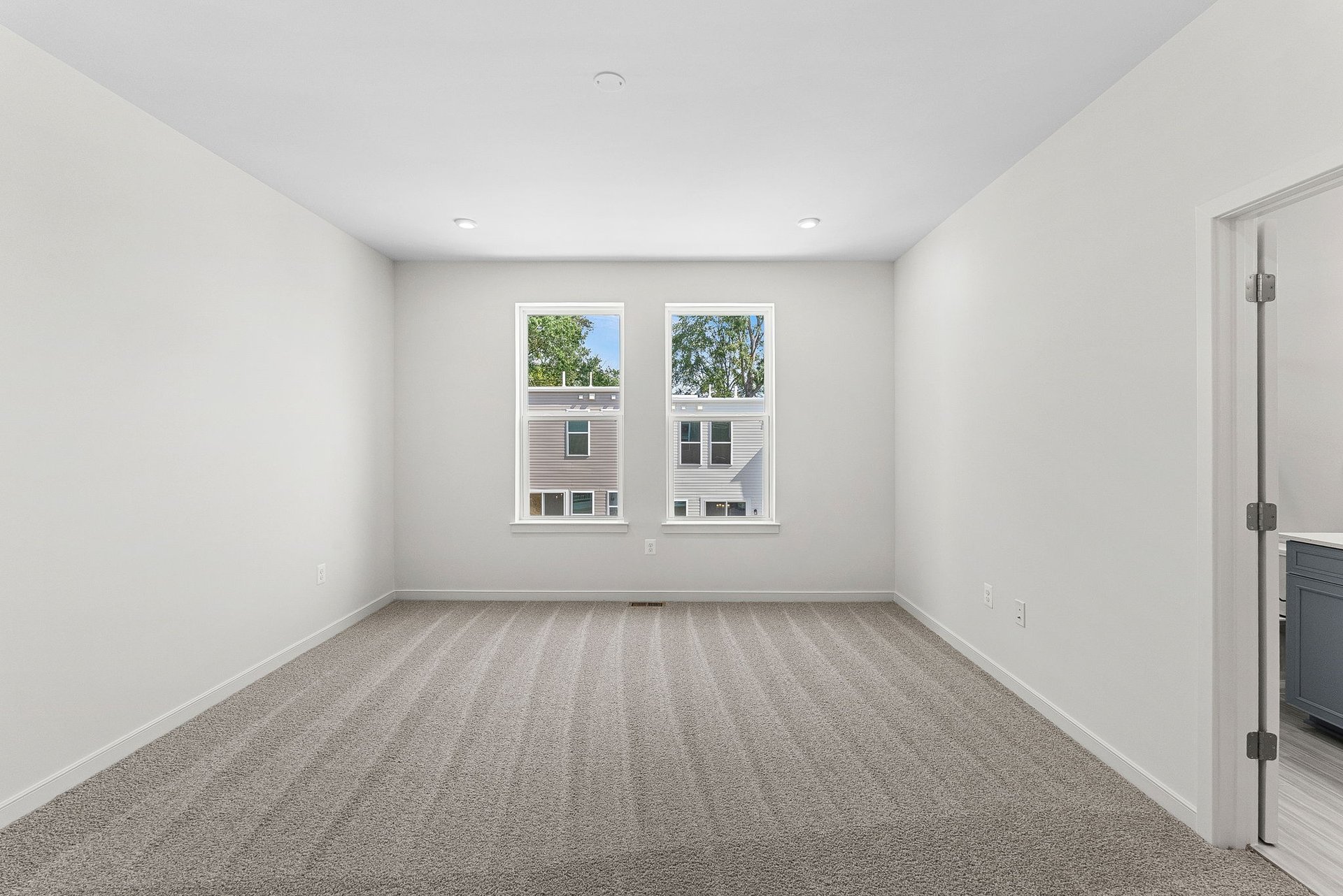 primary bedroom with carpet and windows