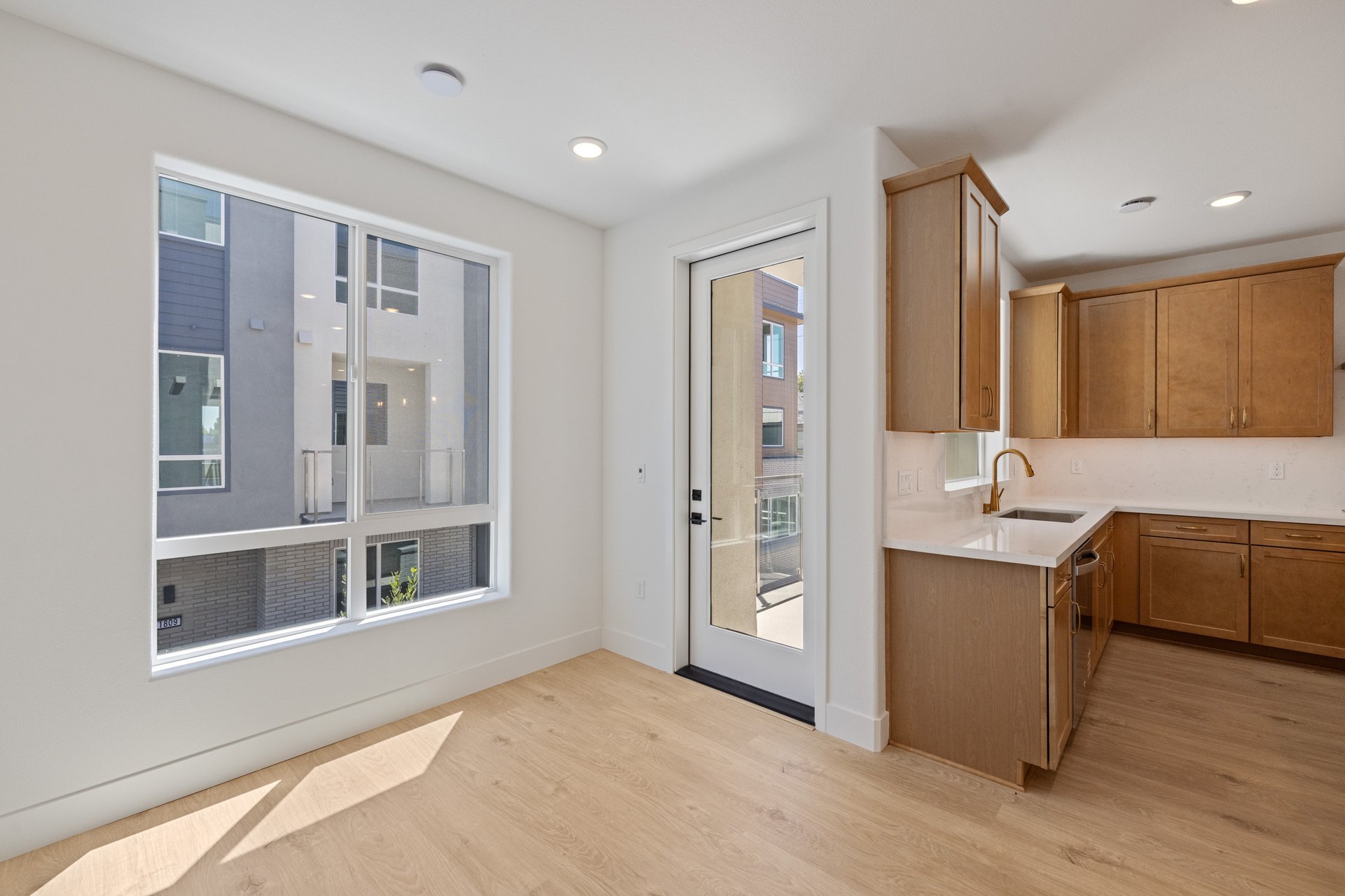 dining room with wood floors, large window, and french door leading to balcony