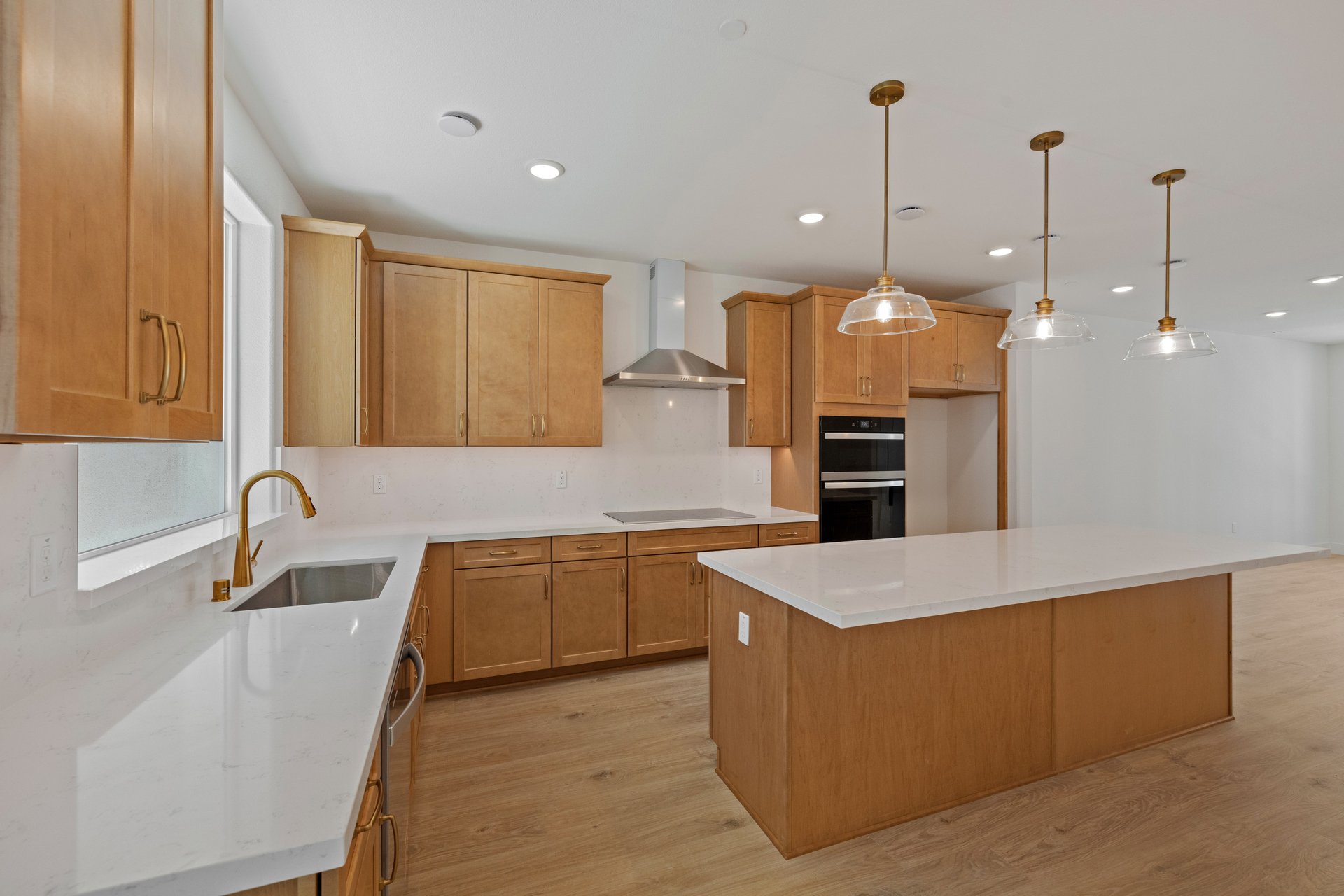 kitchen with brown cabinets, white counters, light wood floors, and island