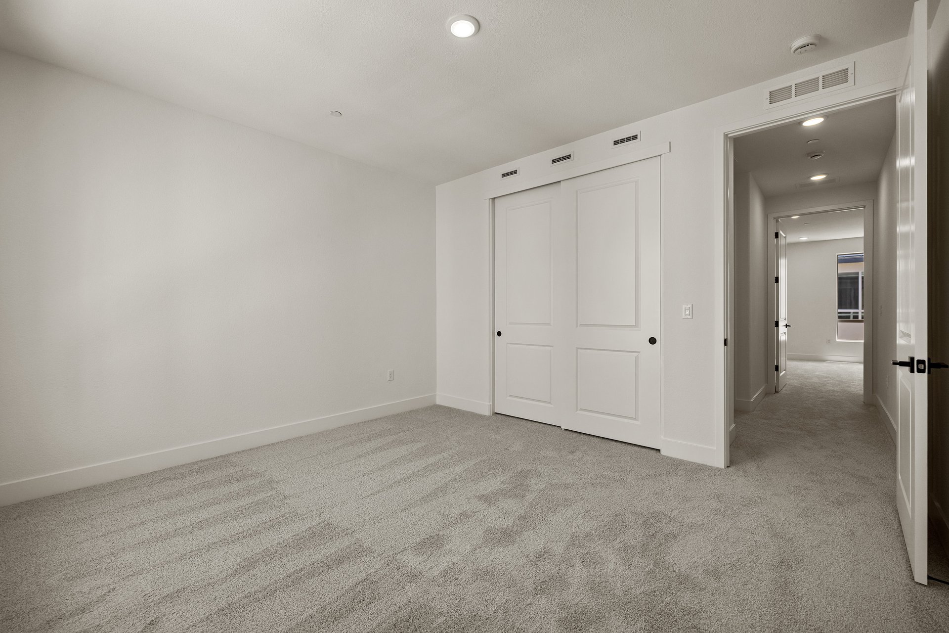 bedroom with gray carpet, white walls, closet, and recessed ceiling light
