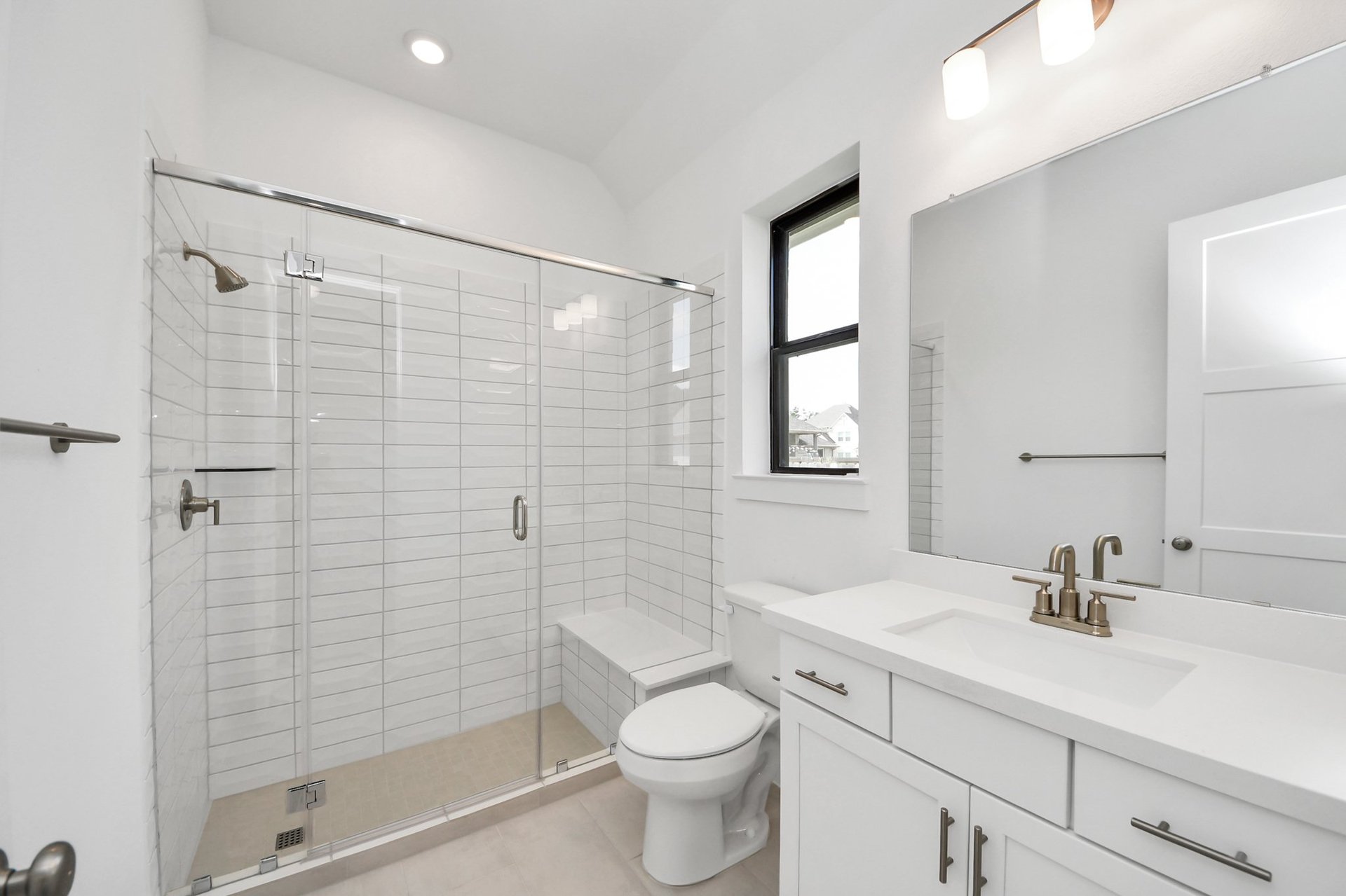 tiled shower and vanity with white cabinets