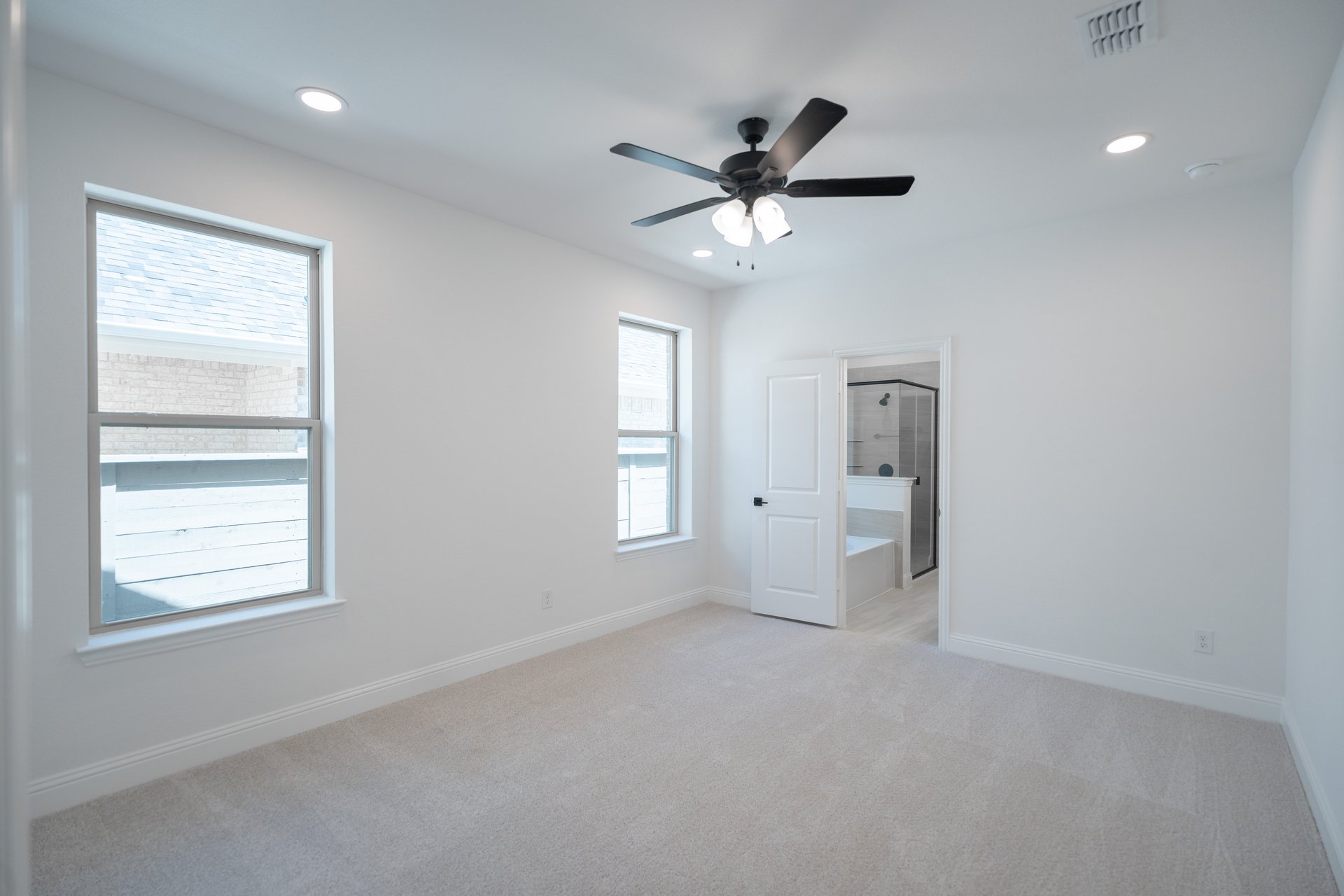 primary bedroom with carpet and ceiling fan