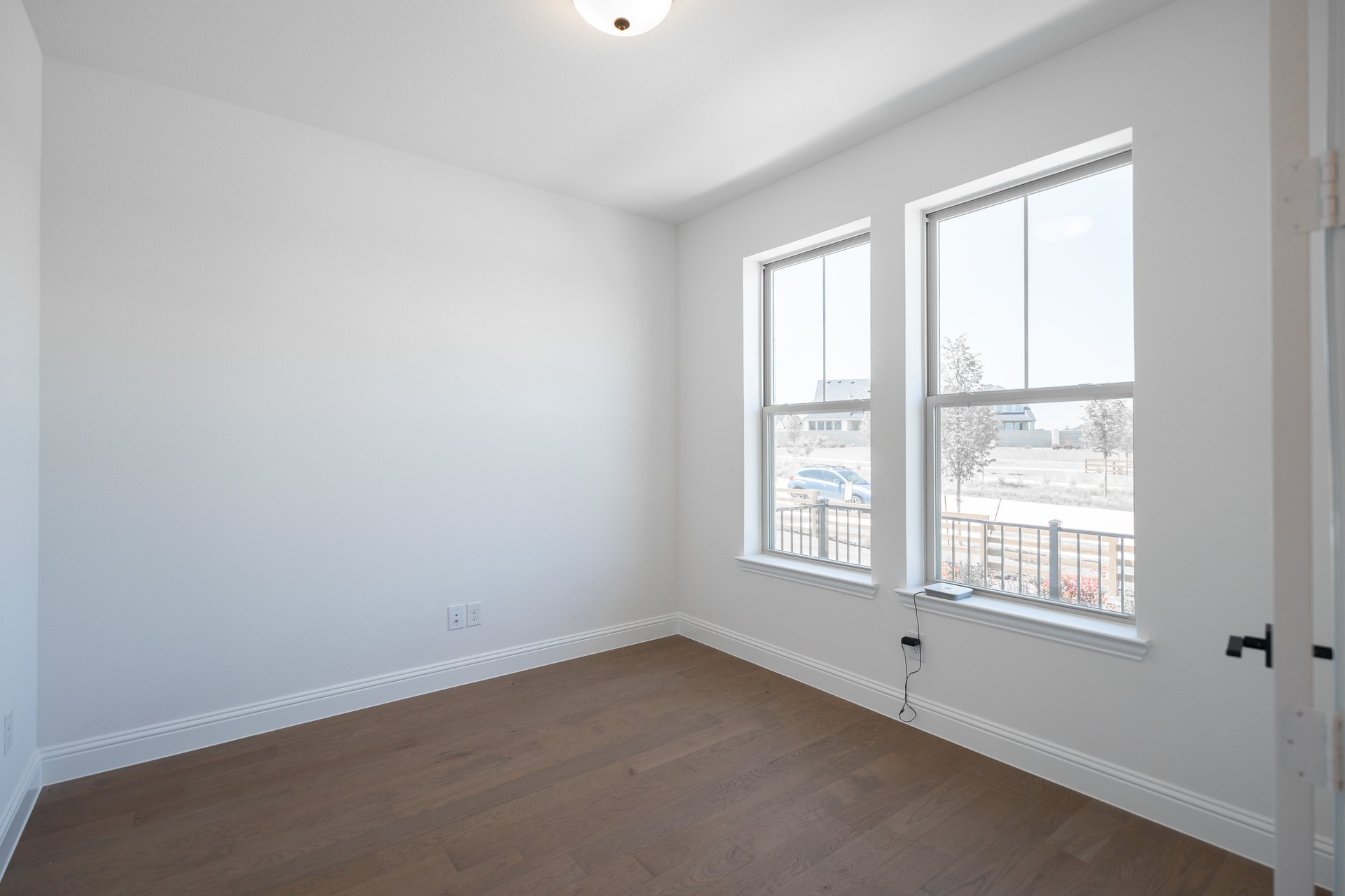private study with wood floors and windows