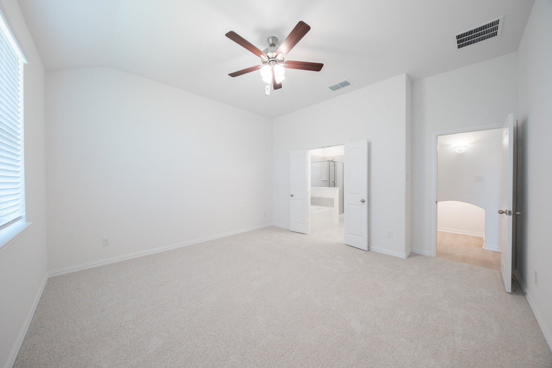 primary bedroom with carpet and ceiling fan