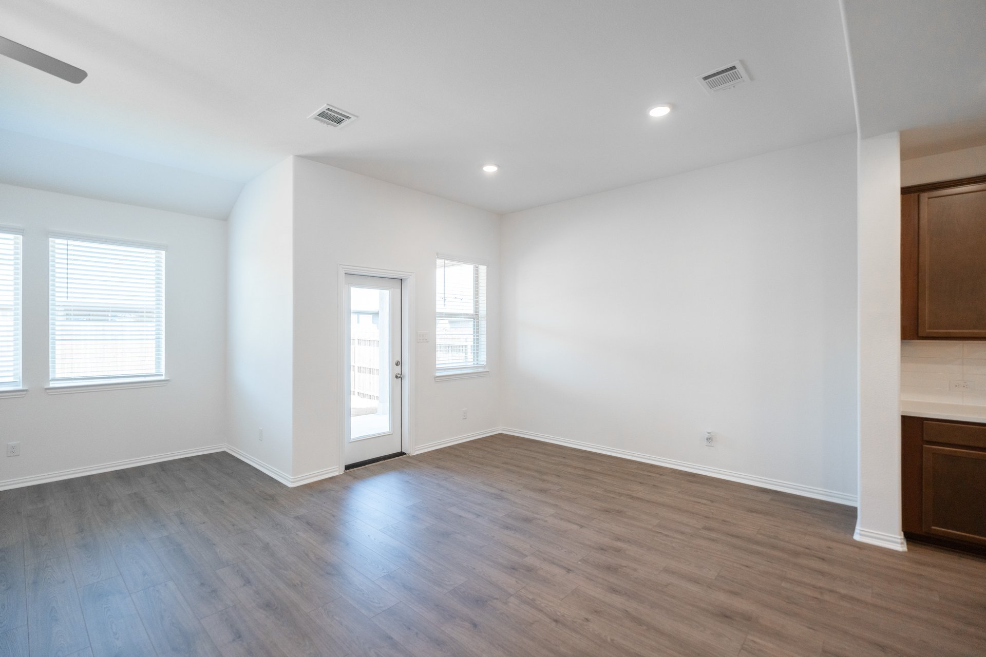 open dining room with wood floors and windows