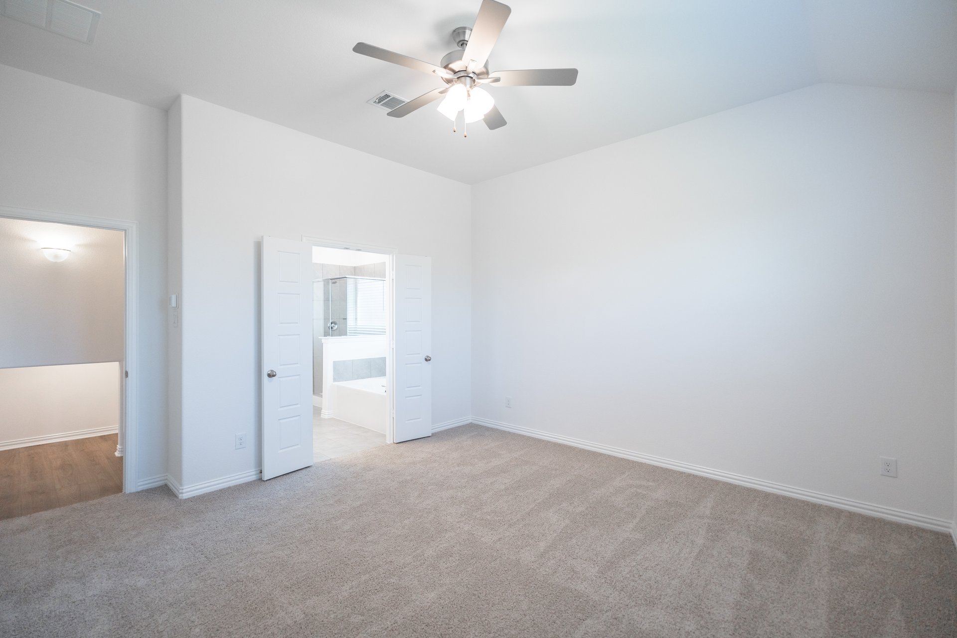 primary bedroom with carpet and ceiling fan