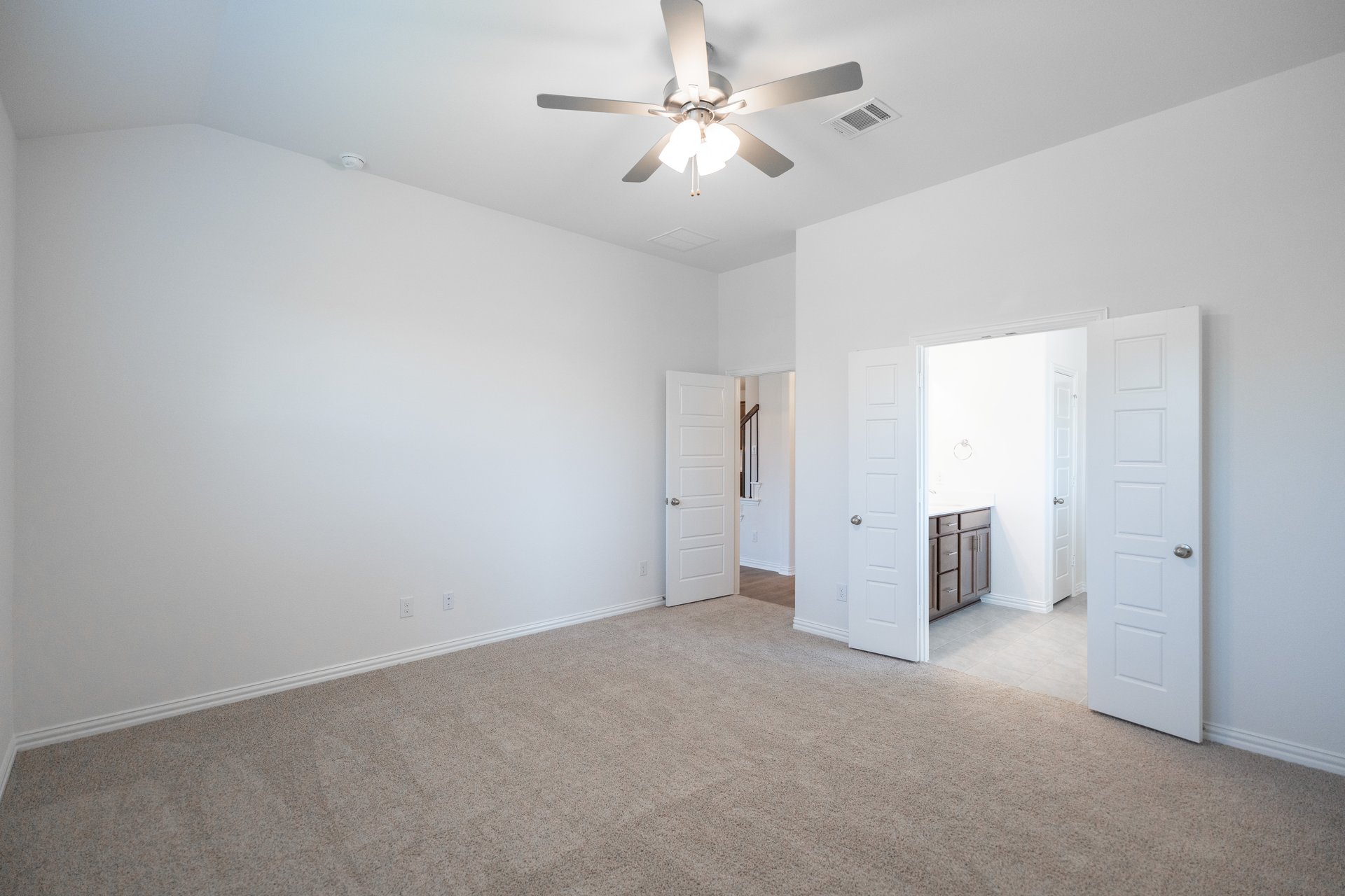 primary bedroom with carpet and ceiling fan