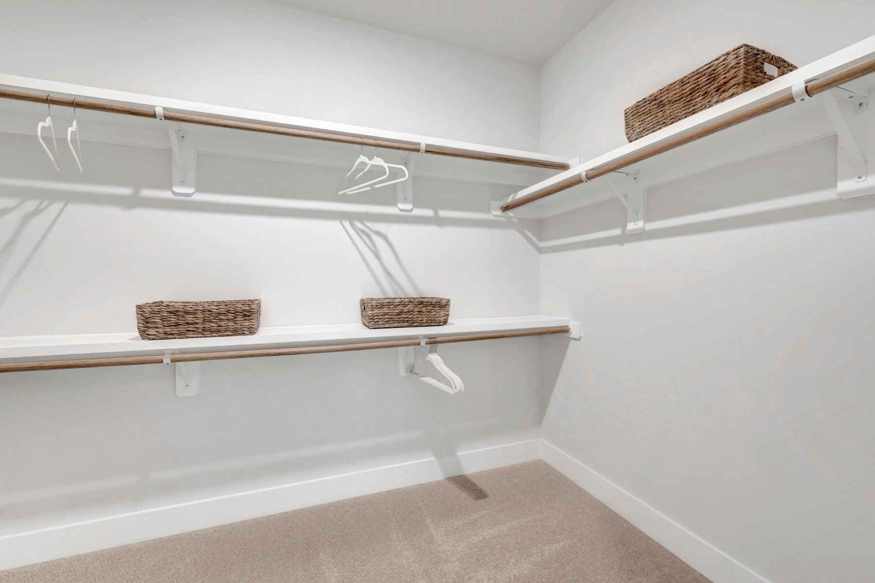 primary closet with wire shelves and carpet