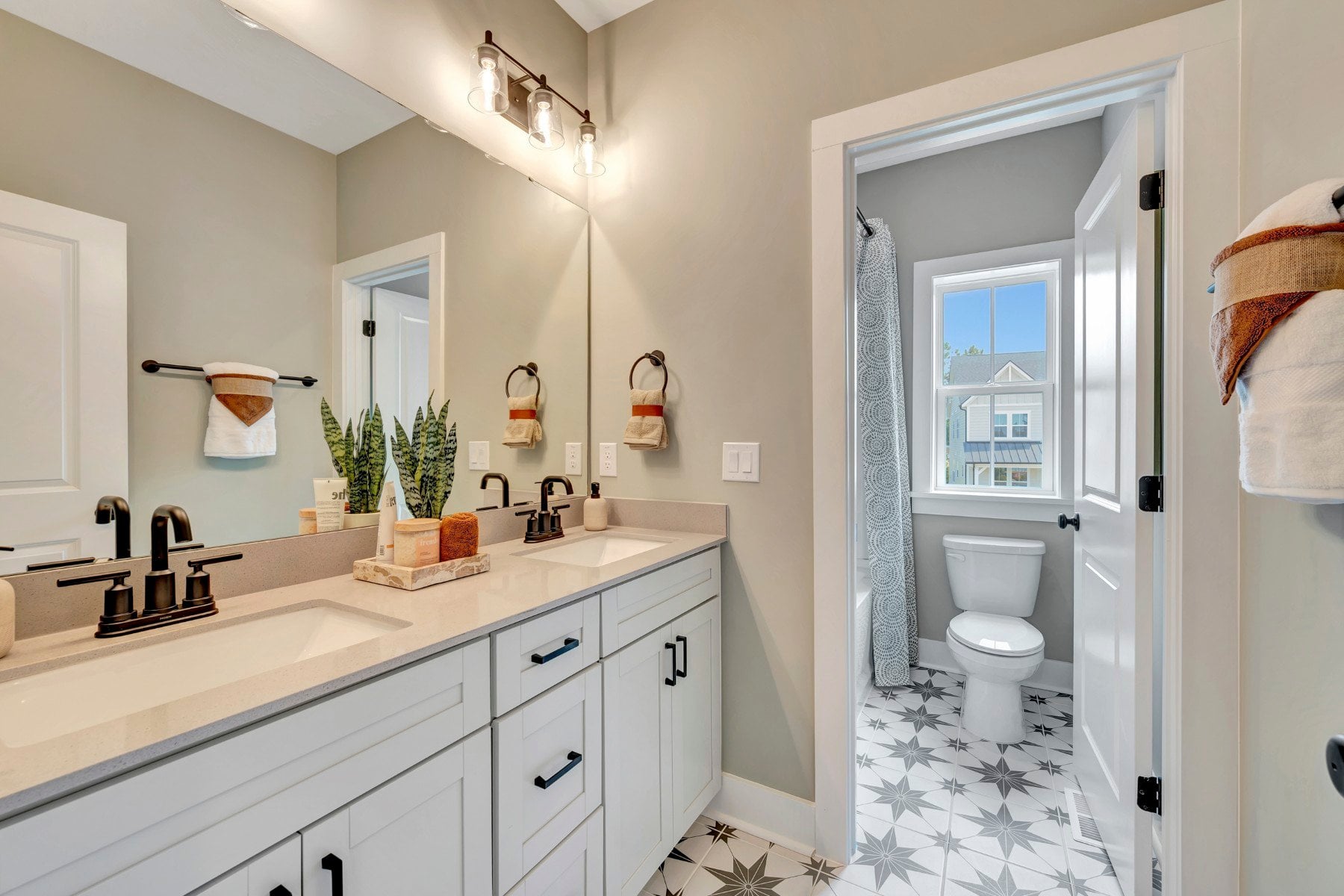 secondary bathroom with two sinks and a window