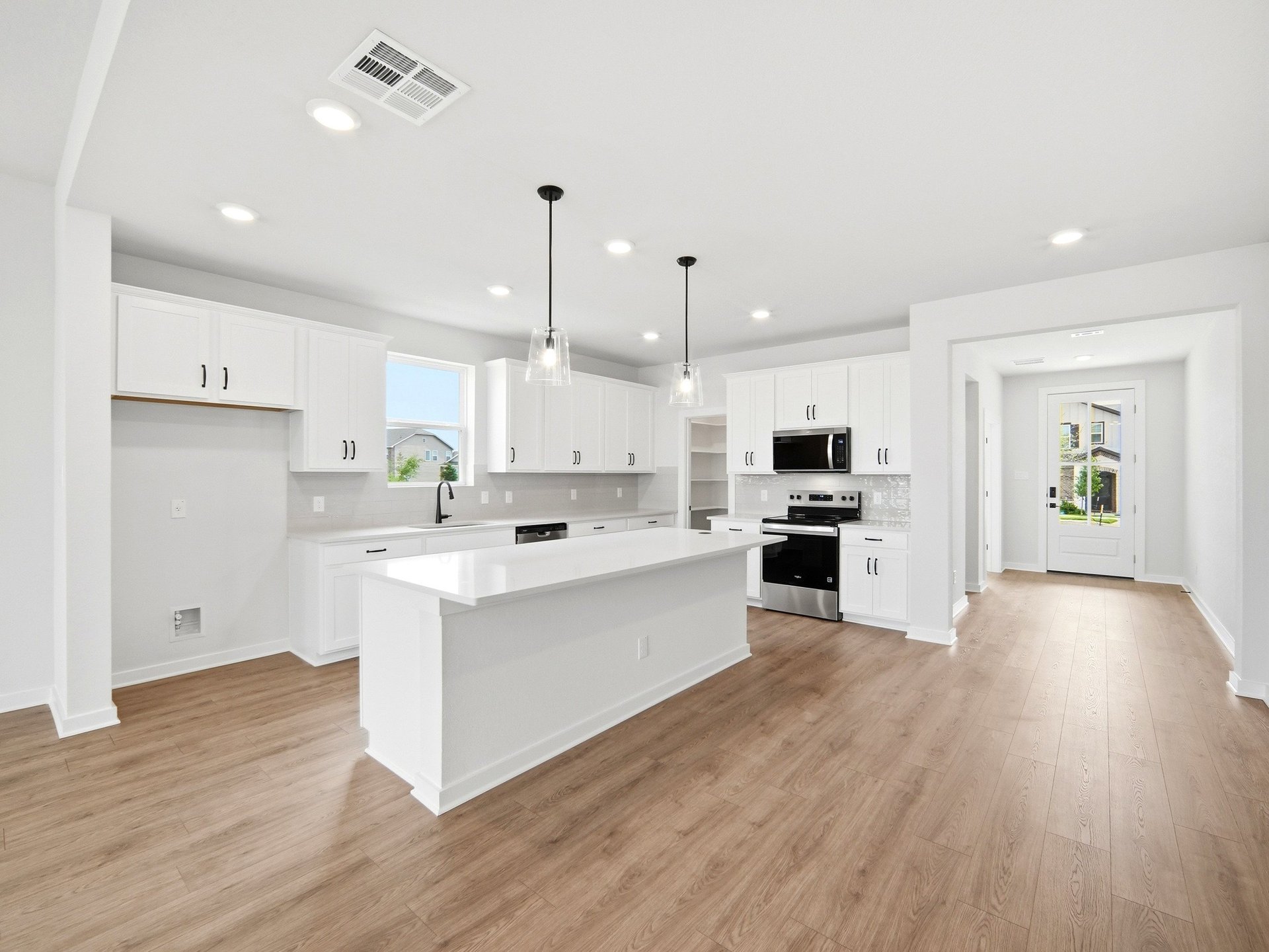 kitchen with white cabinets, quartz countertops, and pendant lighting