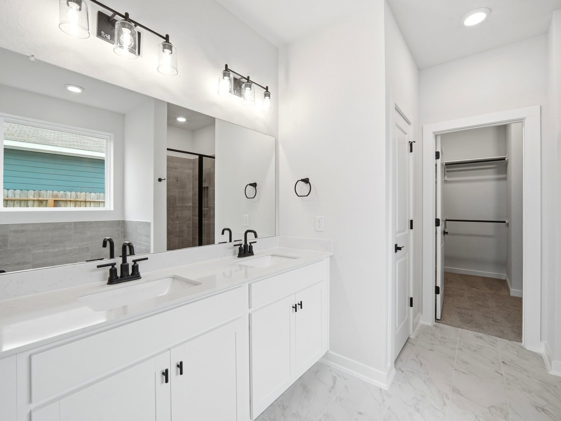 bathroom with dual sinks, quartz countertops and pendant lighting