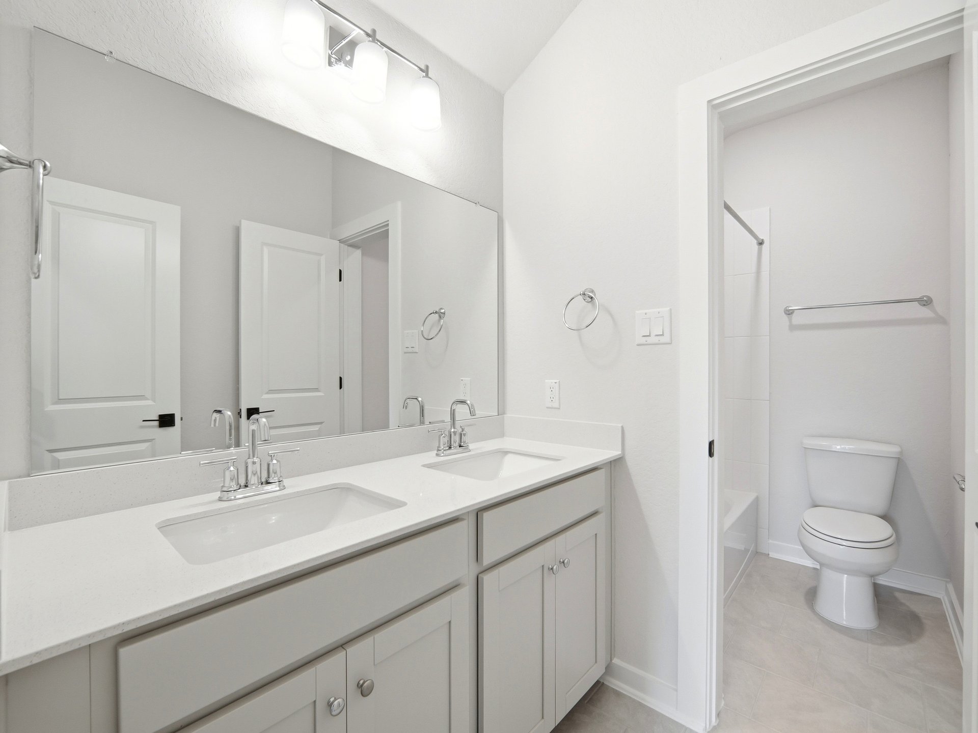 bathroom with dual sinks and soaking tub