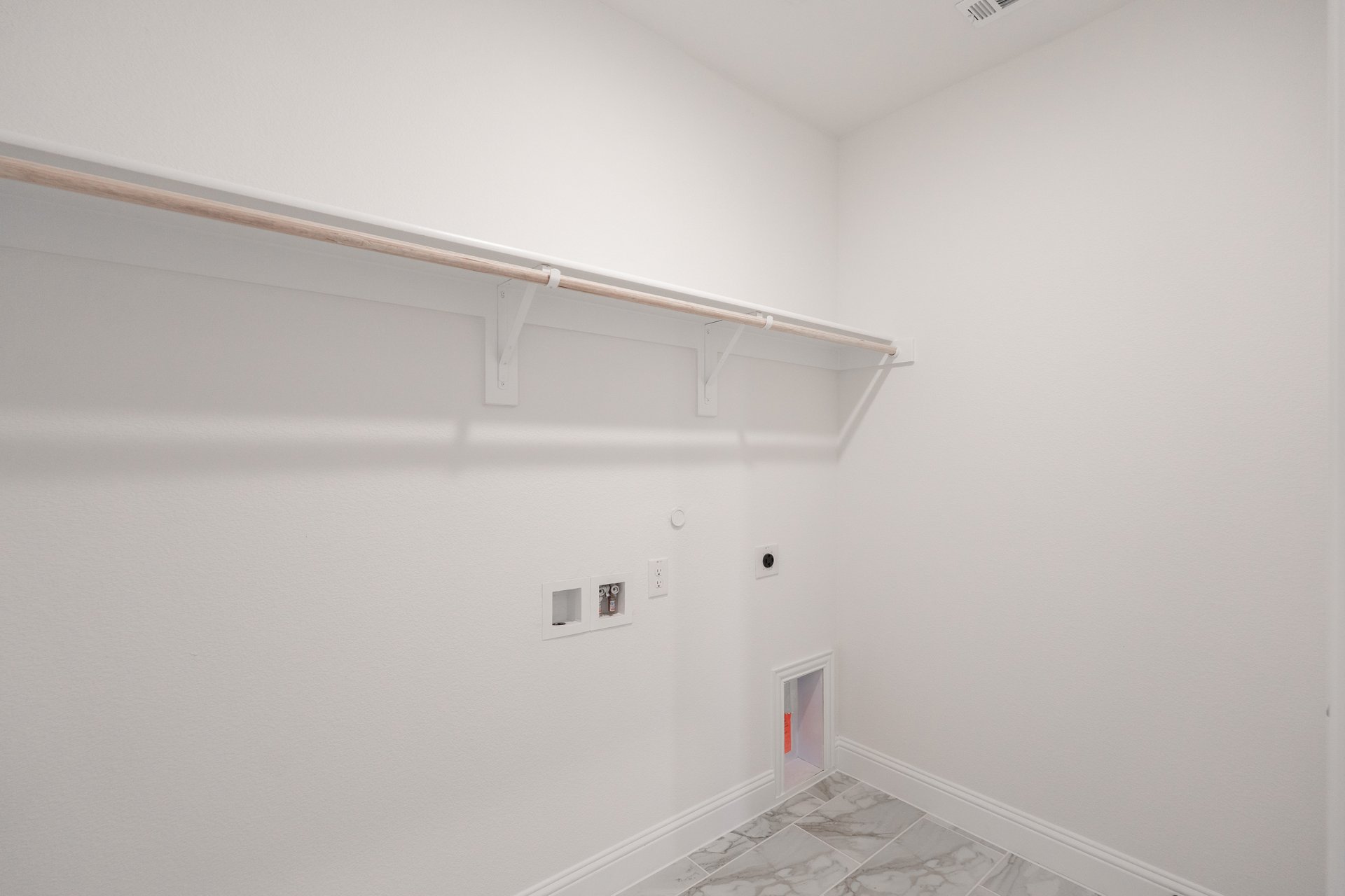 laundry room with tile floors and white shelf