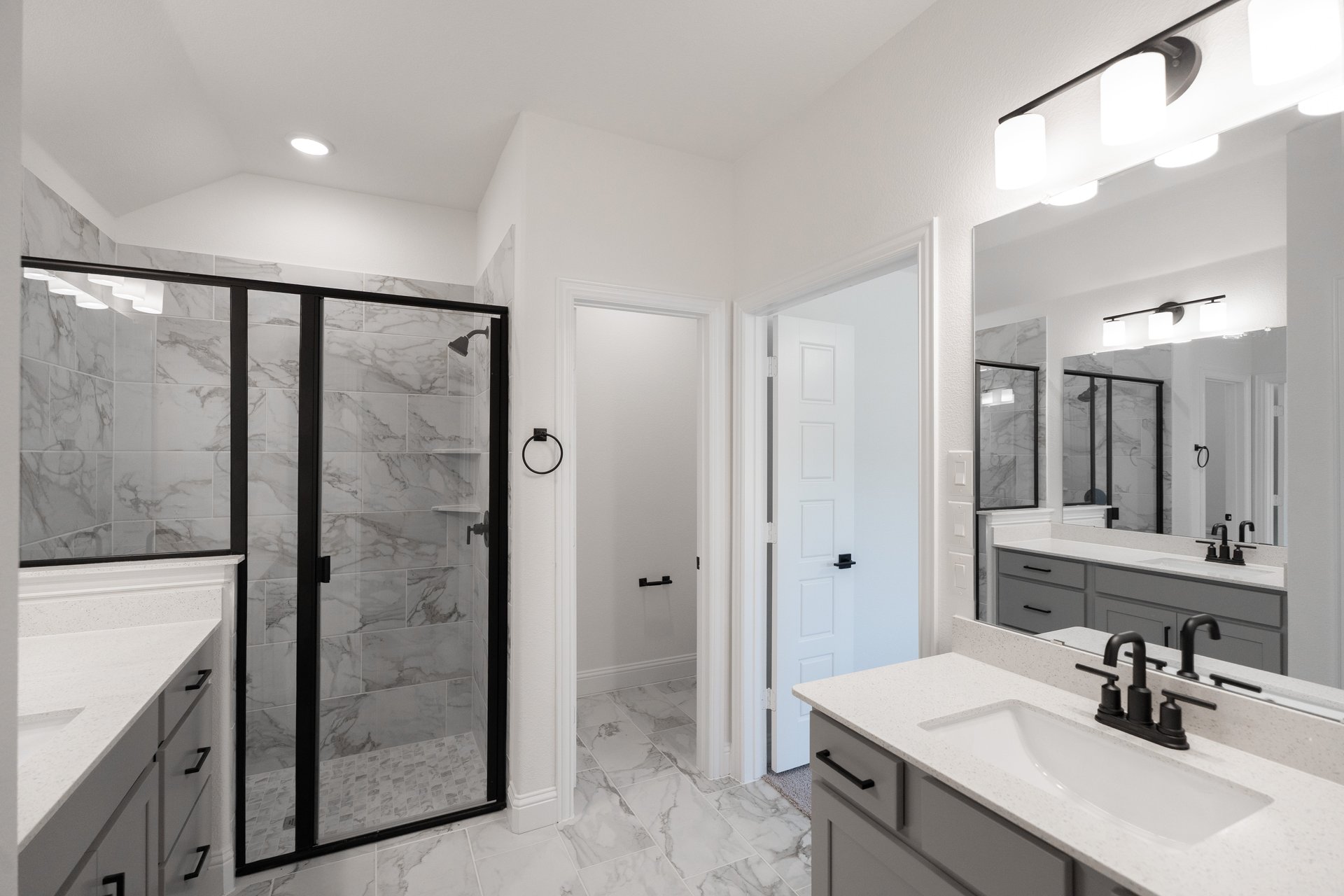primary bathroom with walk-in shower and tile floors