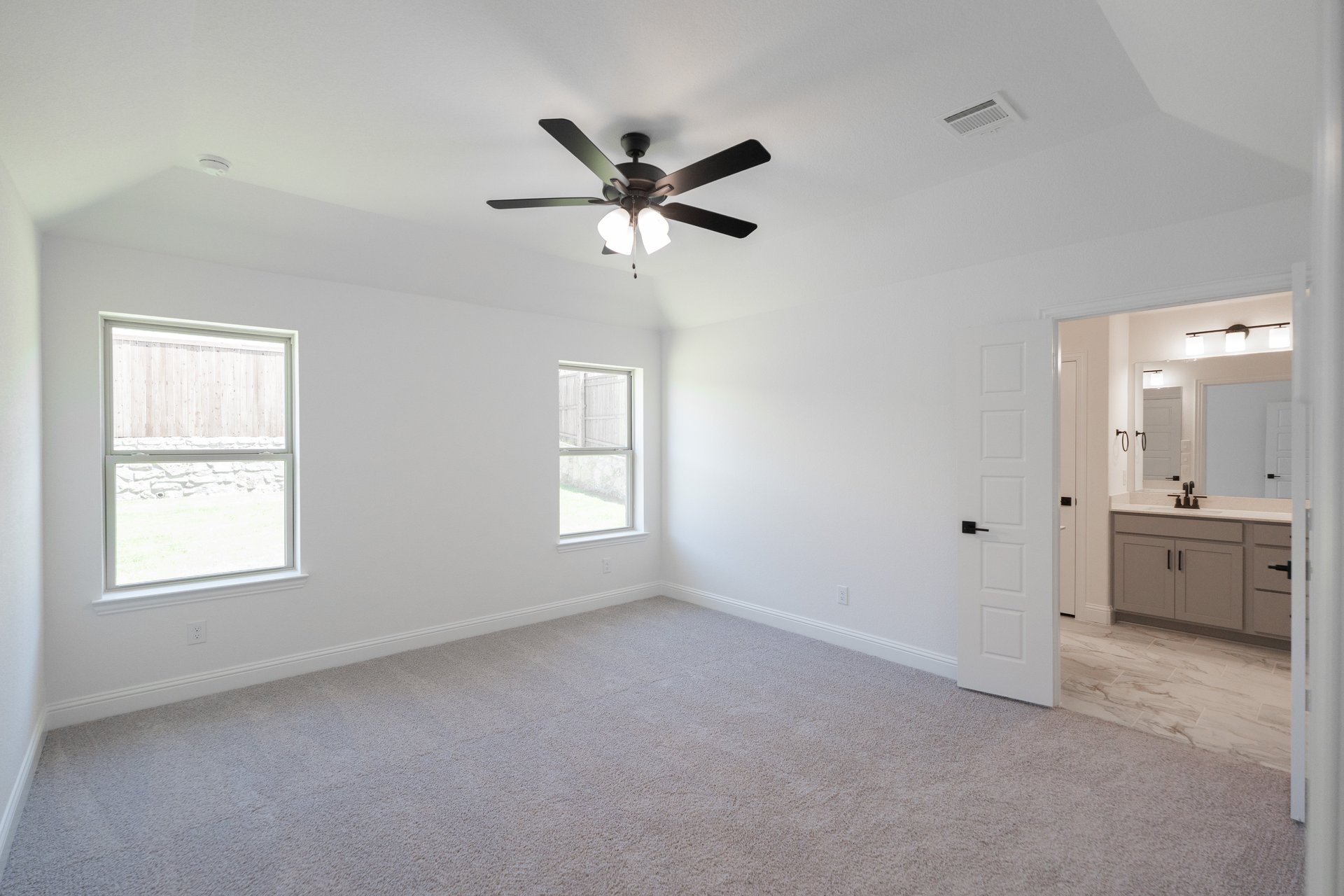 primary bedroom with carpet and ceiling fan