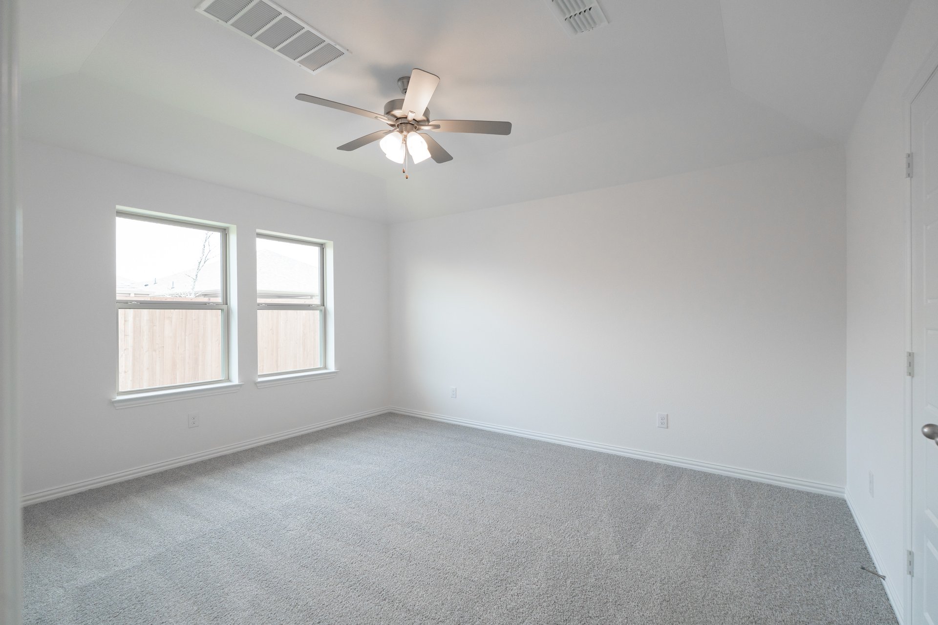 primary bedroom with carpet and windows