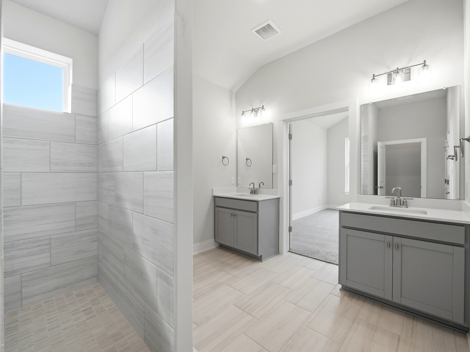 bathroom with dual sinks, quartz counter tops and walk-in shower