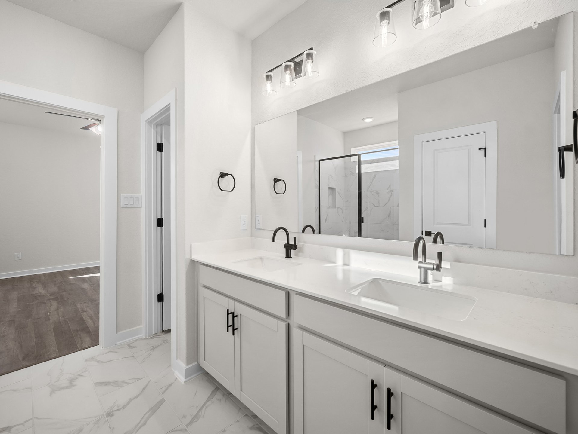 bathroom with dual sinks, quartz countertops & a walk-in shower