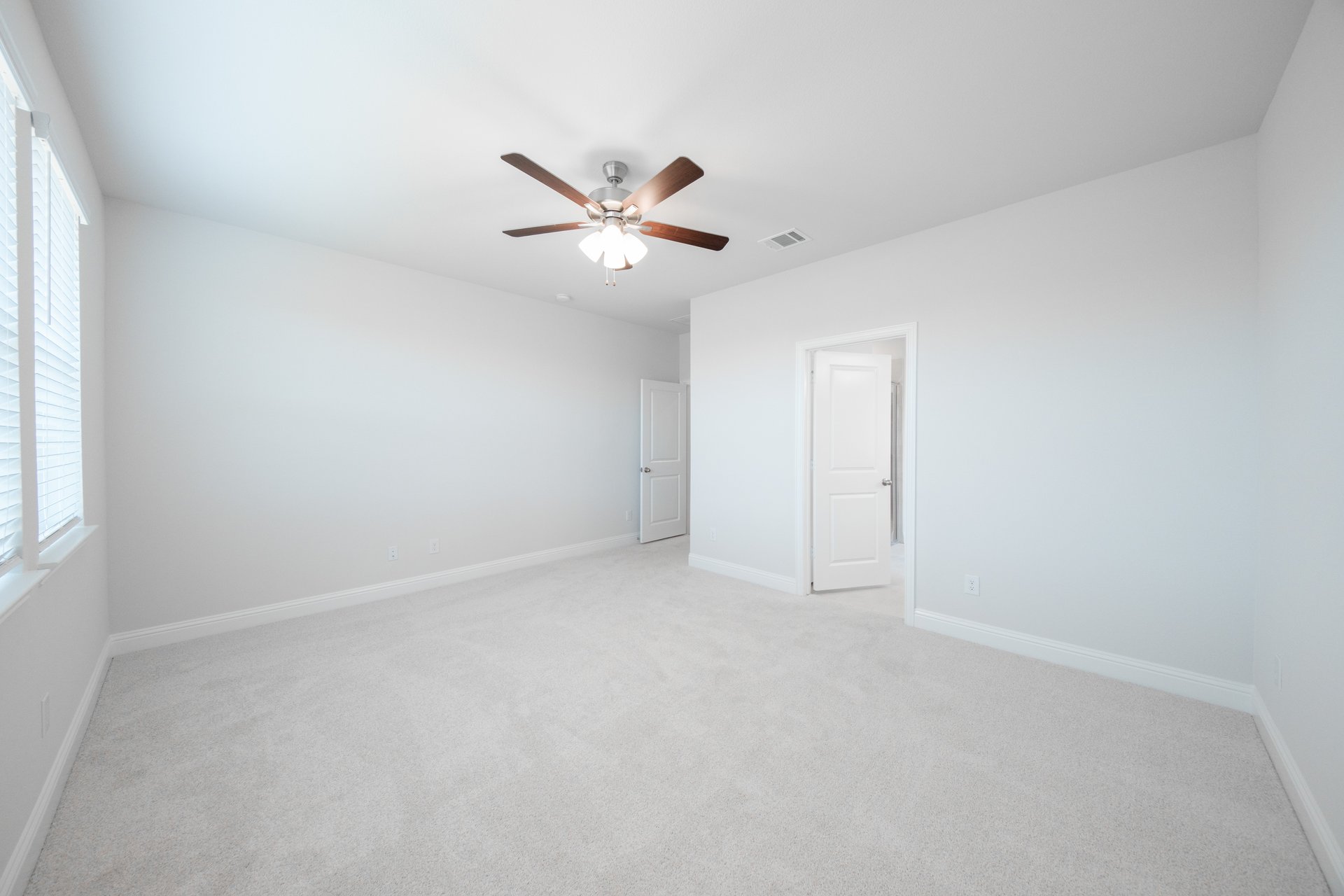 primary bedroom with carpet and ceiling fan