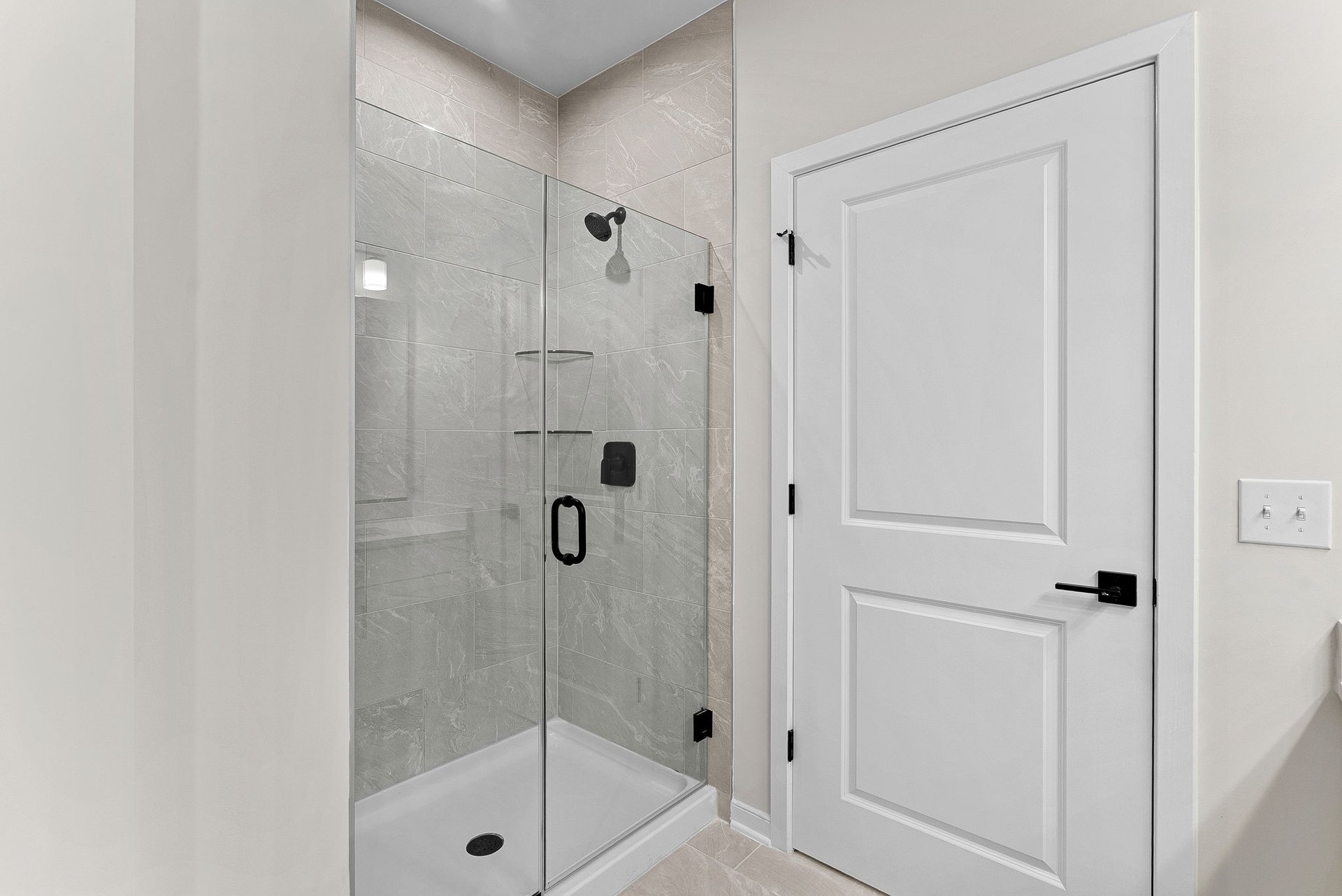 primary bathroom with shower with black hardware and tile