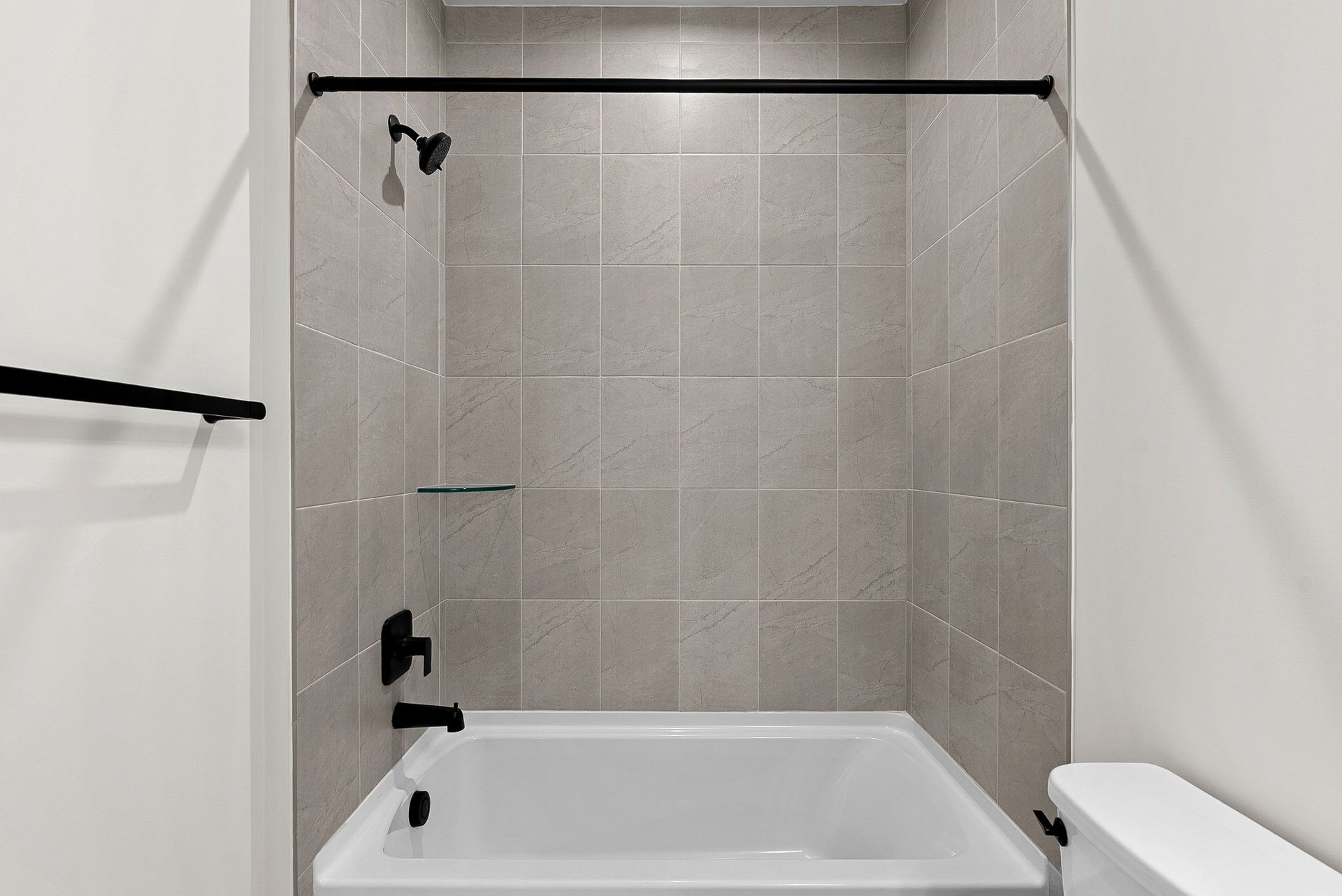 Secondary bathroom with shower and tub with black hardware and tile
