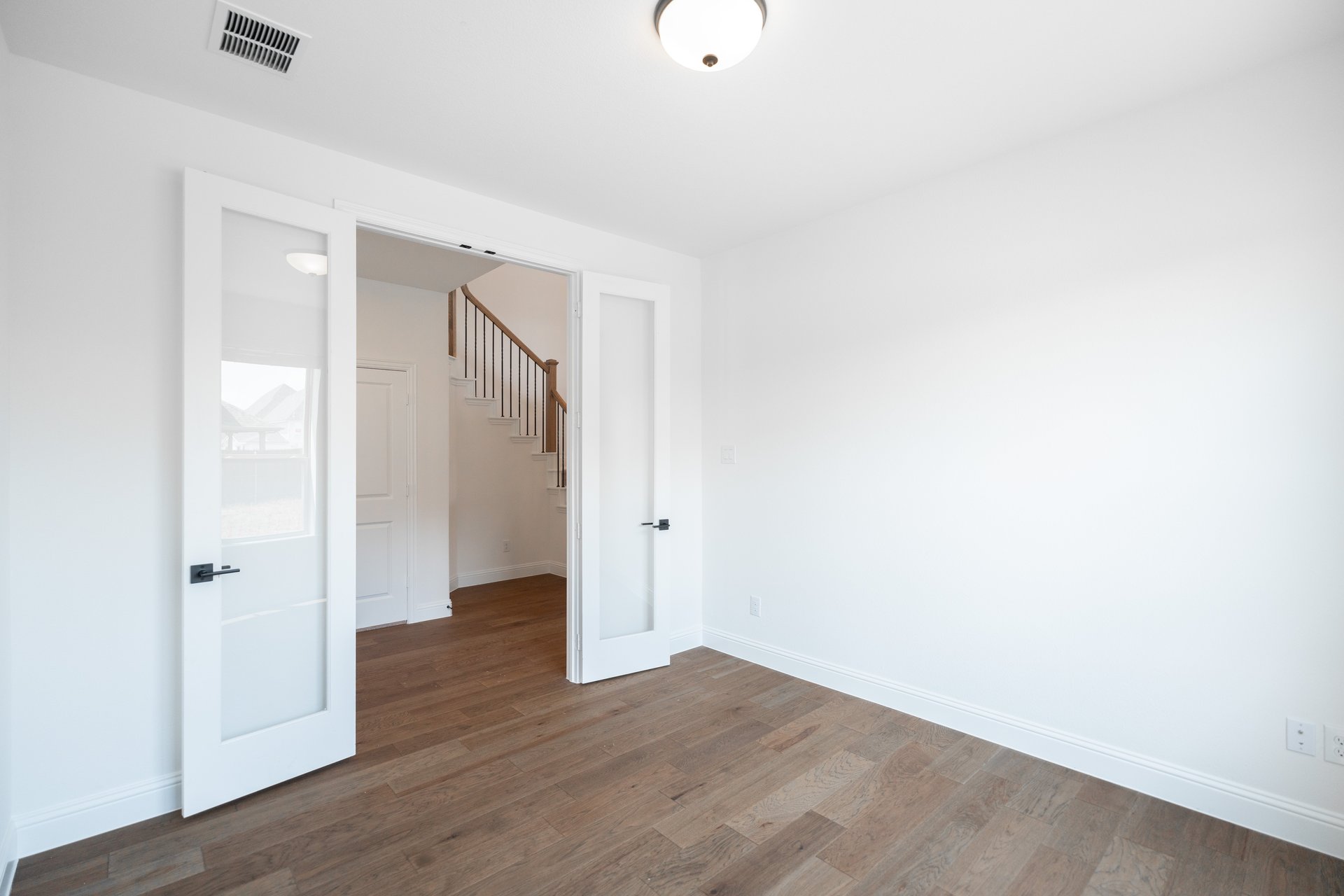 private study with wood floors and windows