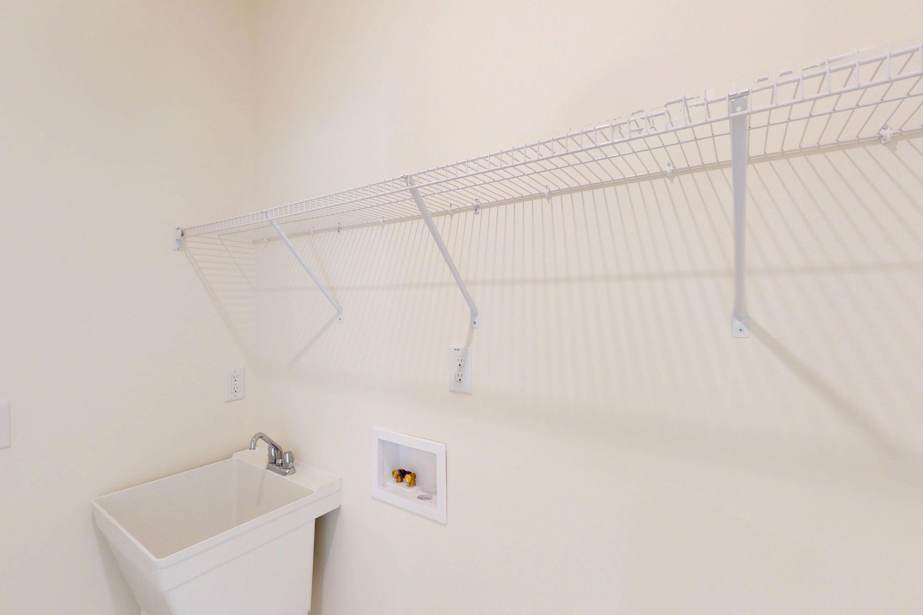 laundry room with a sink and a wire shelf