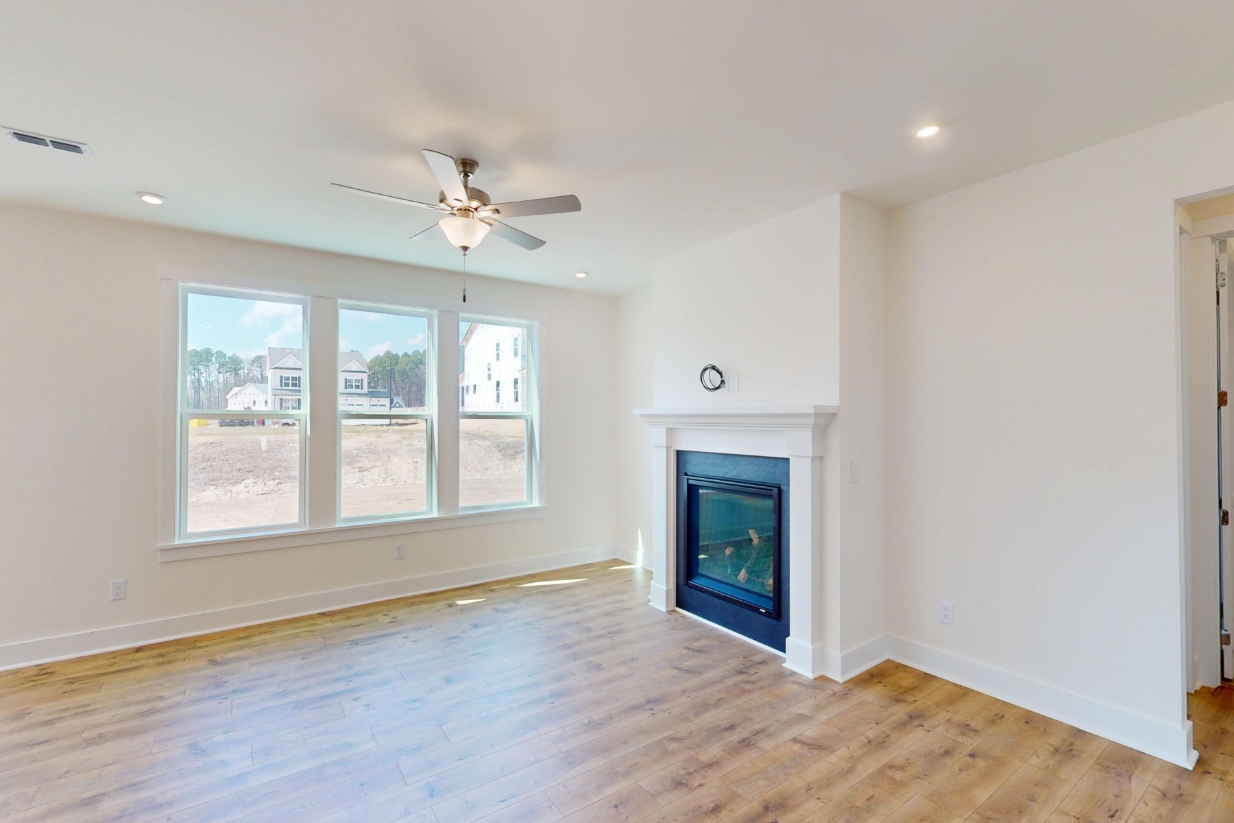 great room with three windows and a fireplace