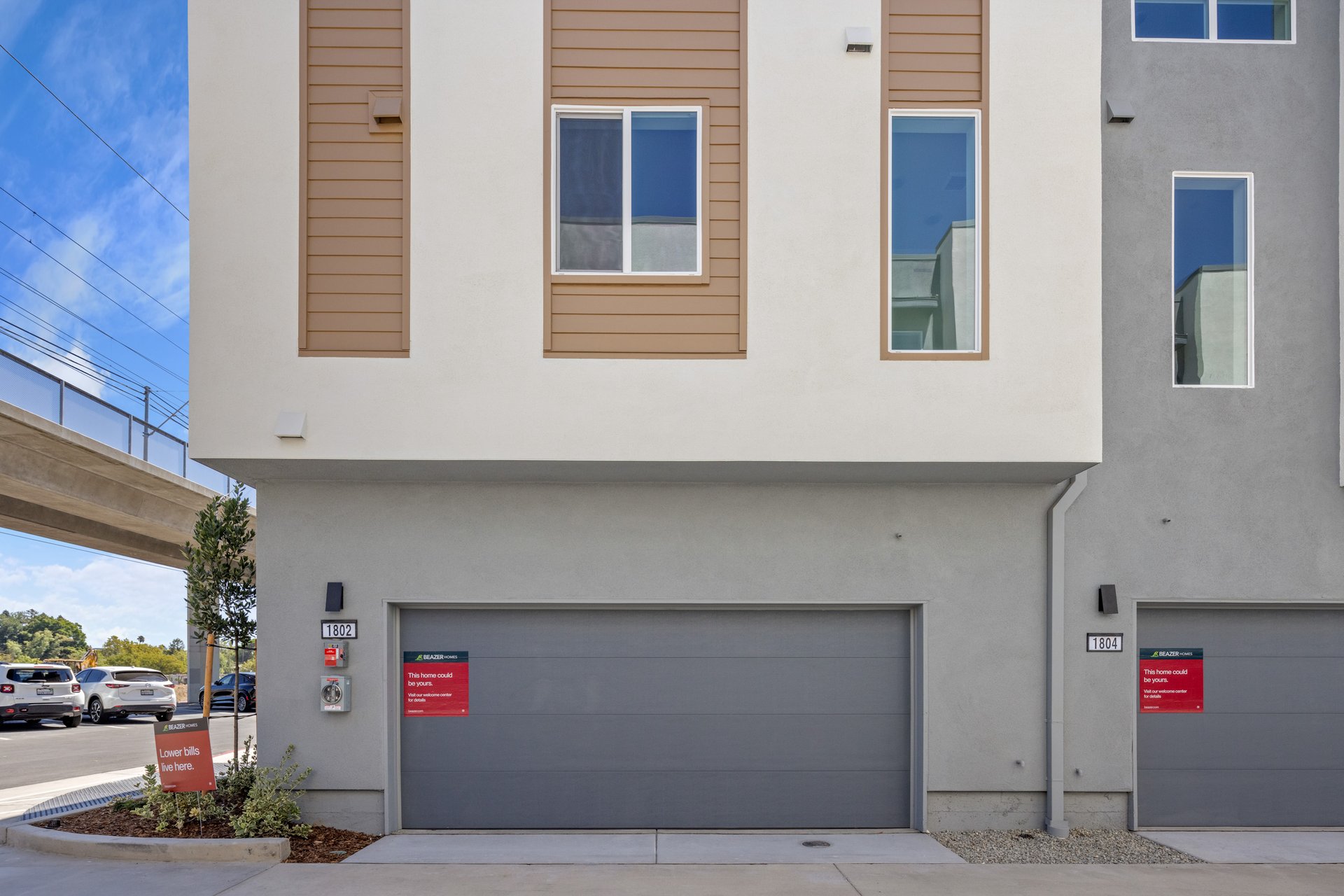 back exterior of gray and white condo building showing two-car attached garages