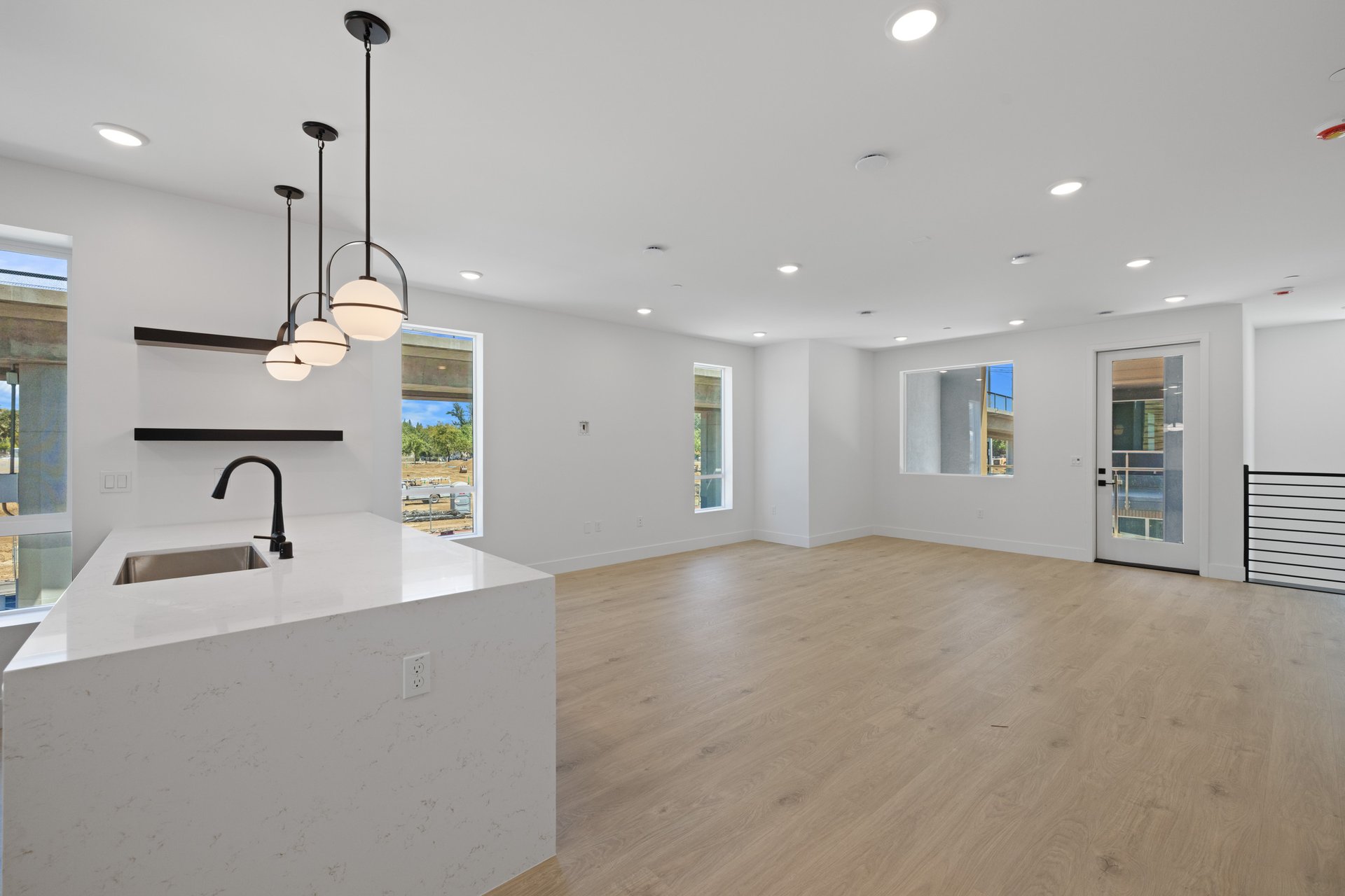 great room with light wood floors, white walls, multiple windows, and recessed ceiling lights