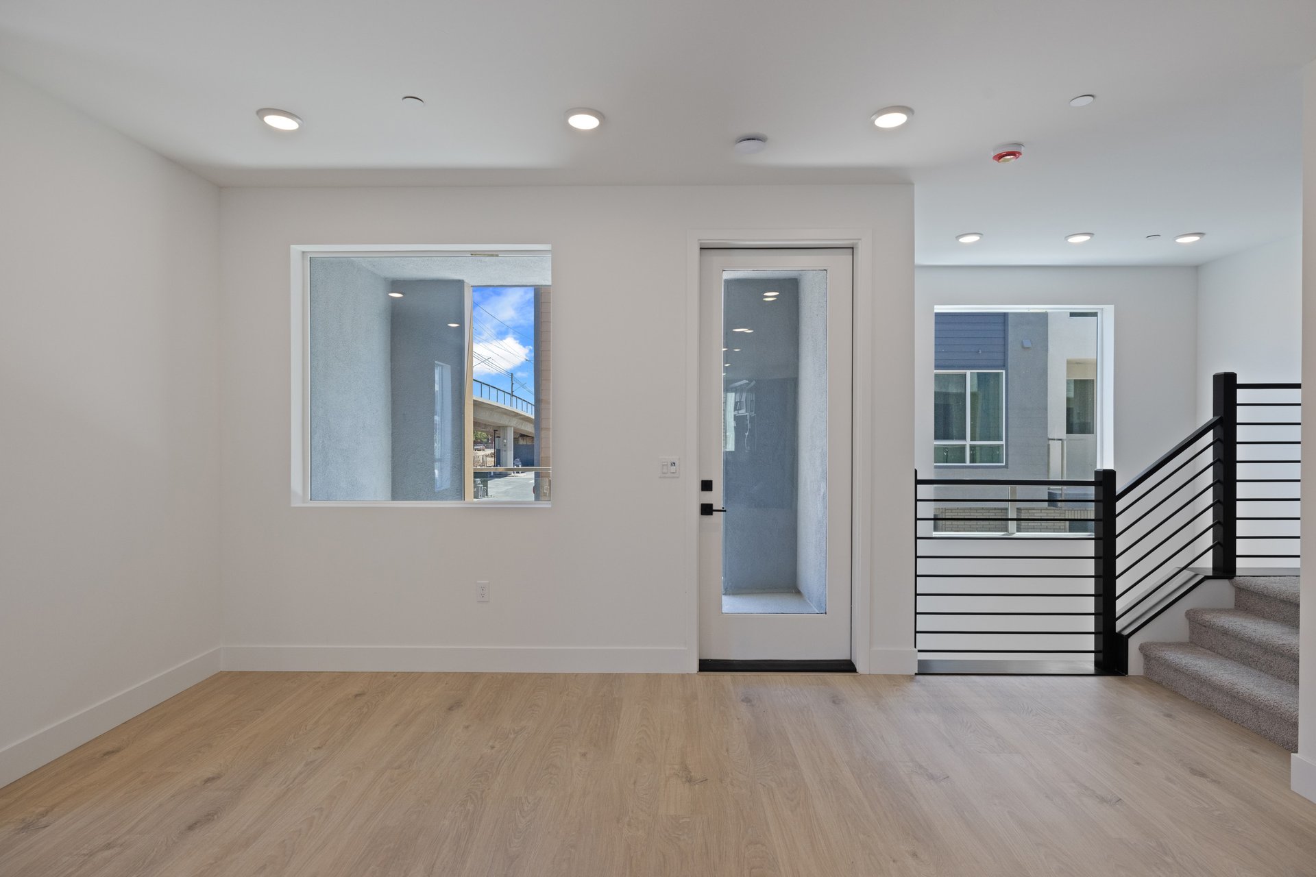 dining room with light wood floors, two large windows, and french door leading to balcony