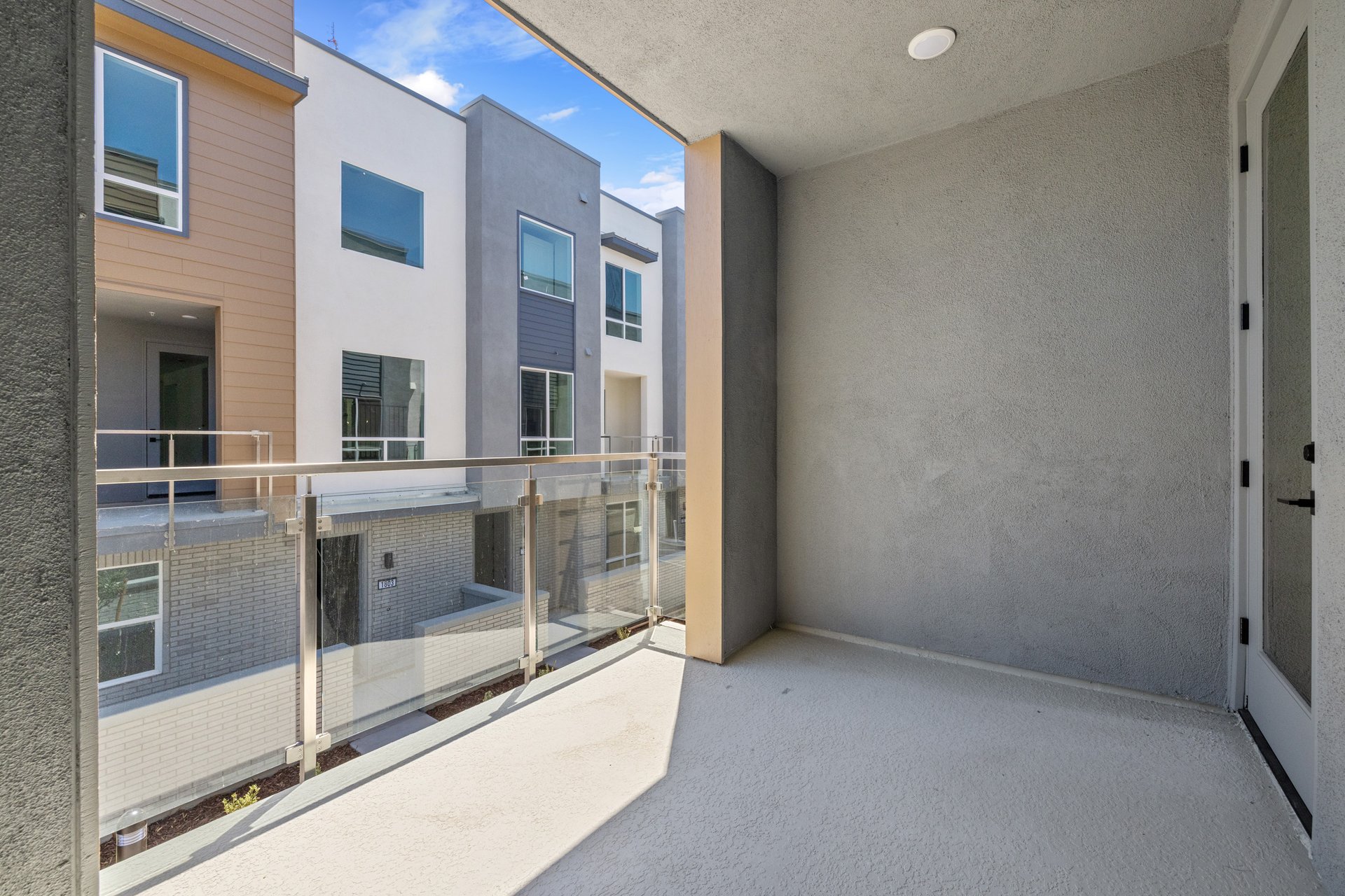 outdoor balcony with glass enclosure and view of building