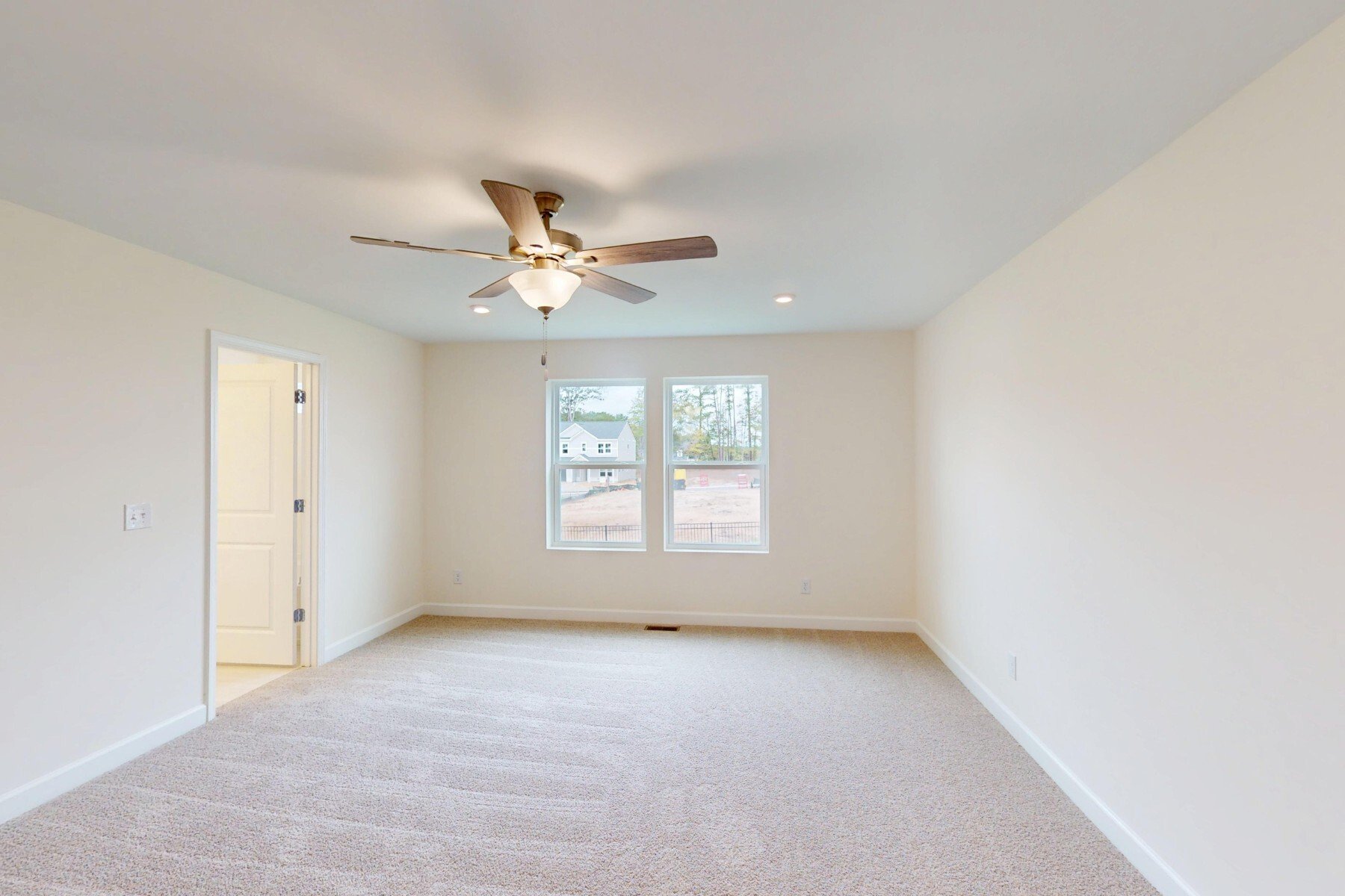 primary bedroom with windows and a ceiling fan
