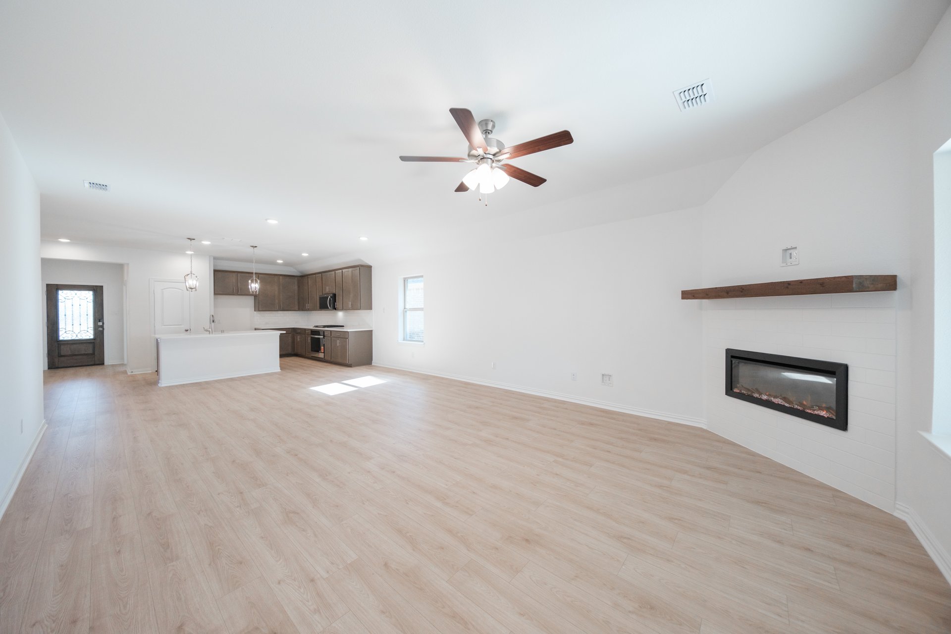 open great room with wood floors and fireplace