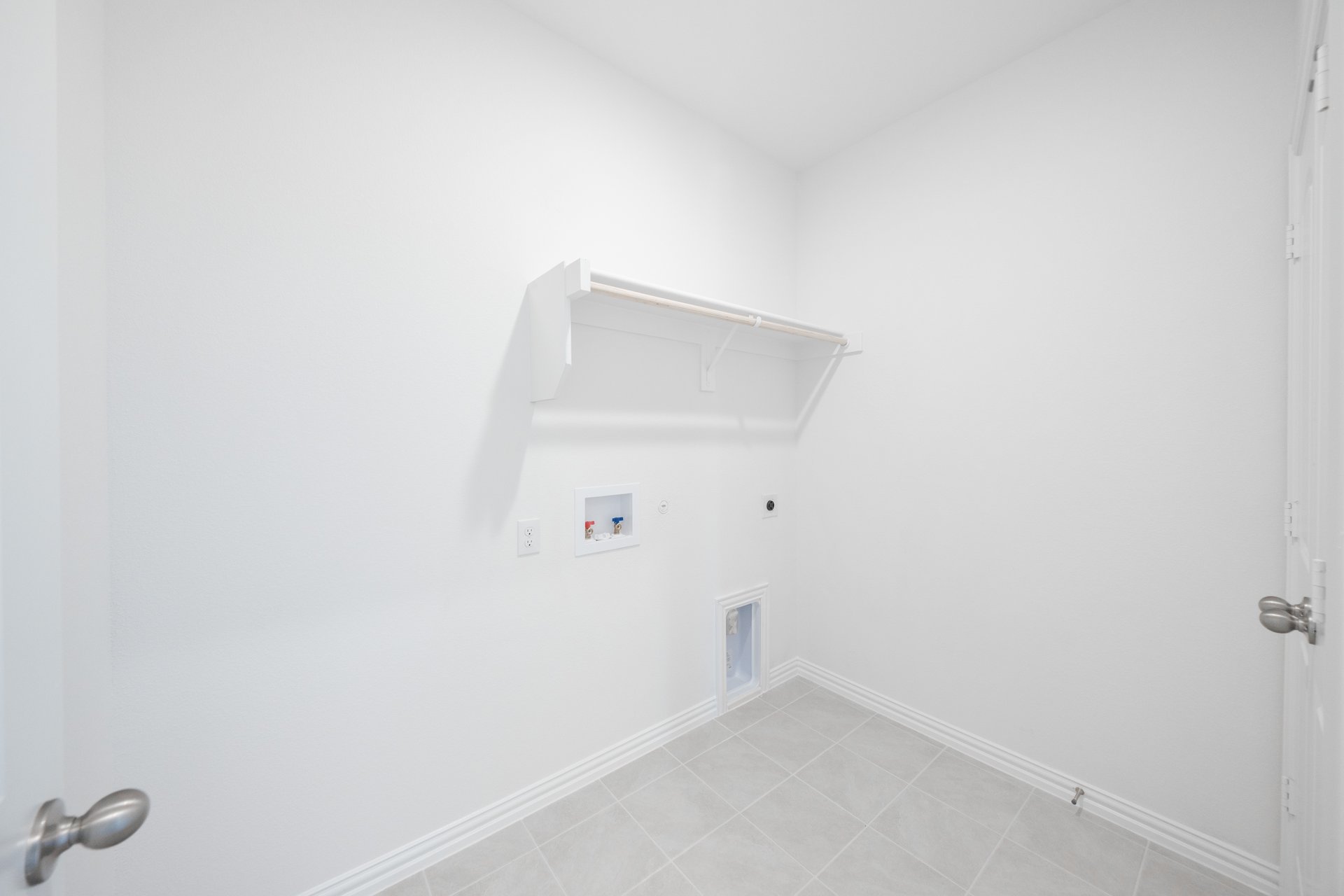 laundry room with tile floors and white shelf