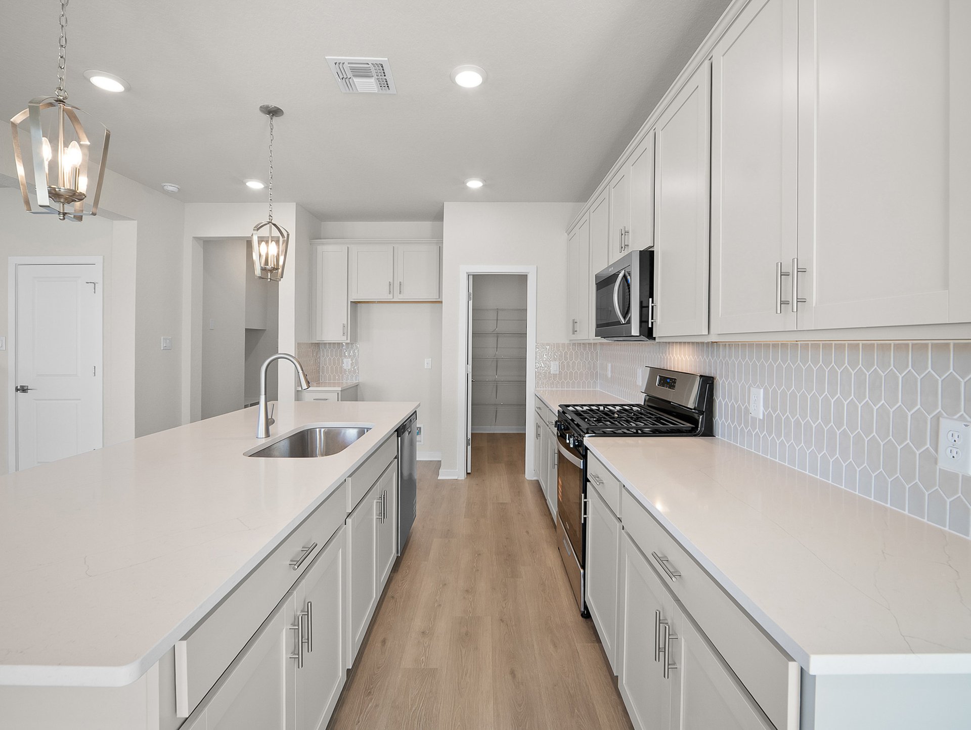 kitchen with quartz countertops, pendant lighting & an island