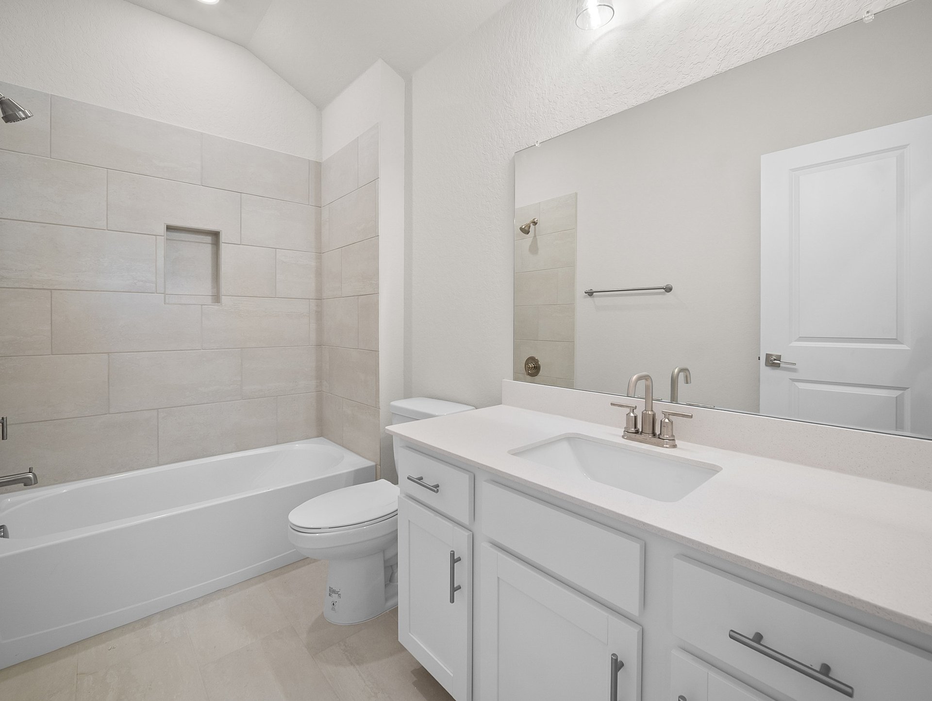 bathroom with soaking tub, quartz countertops & a sink