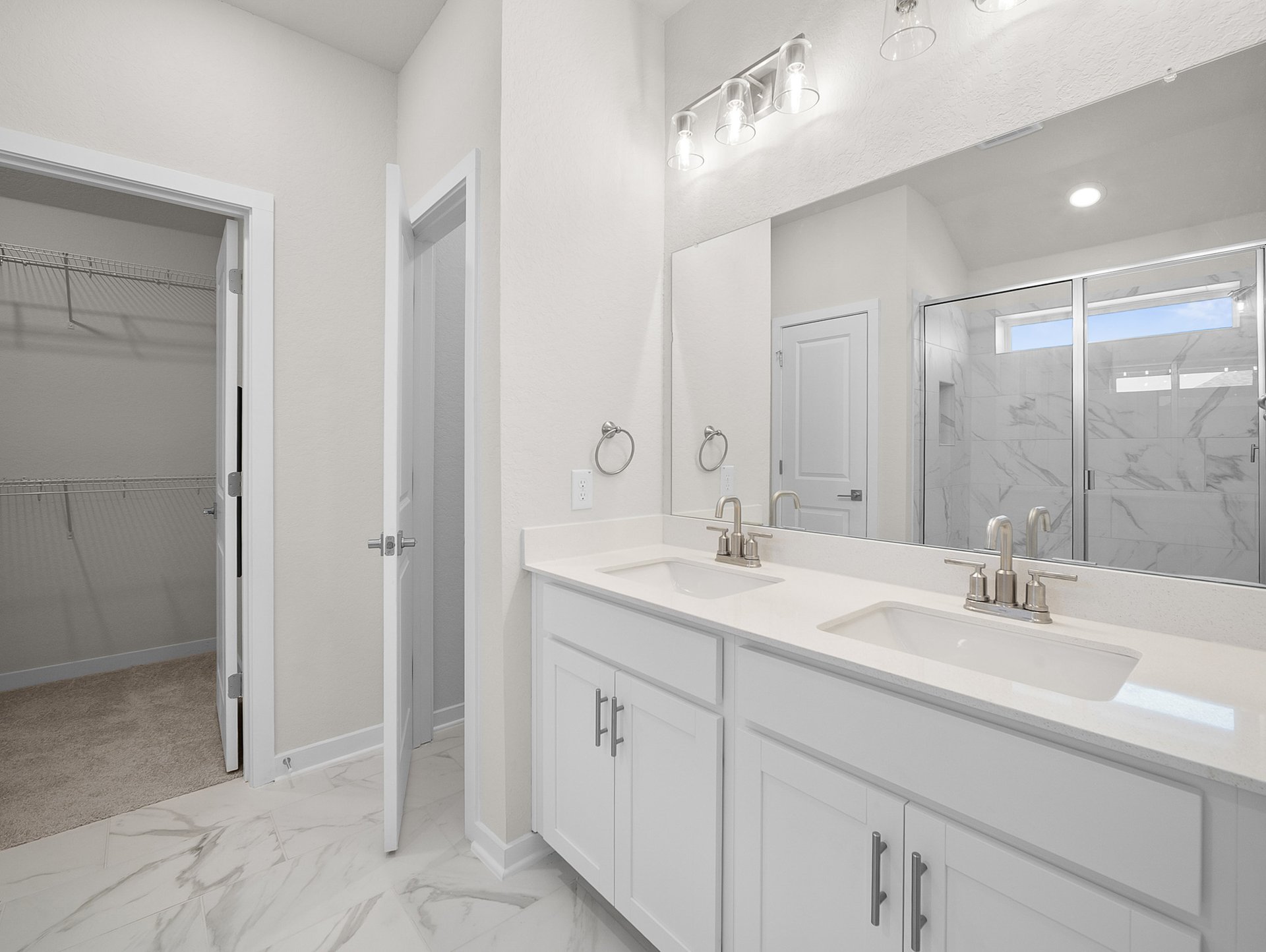 bathroom with a walk-in shower, quartz countertops & dual sinks