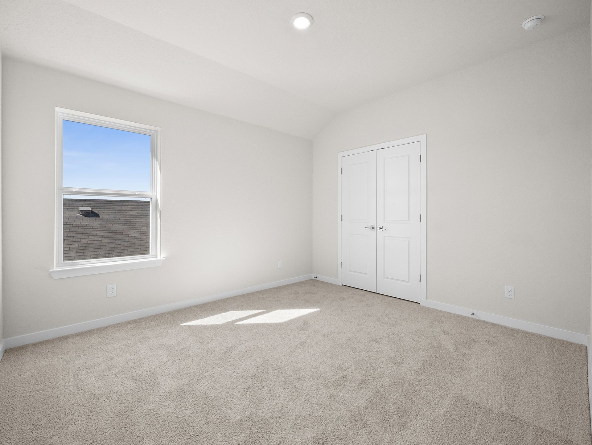 bedroom with carpet, window & a sloped ceiling