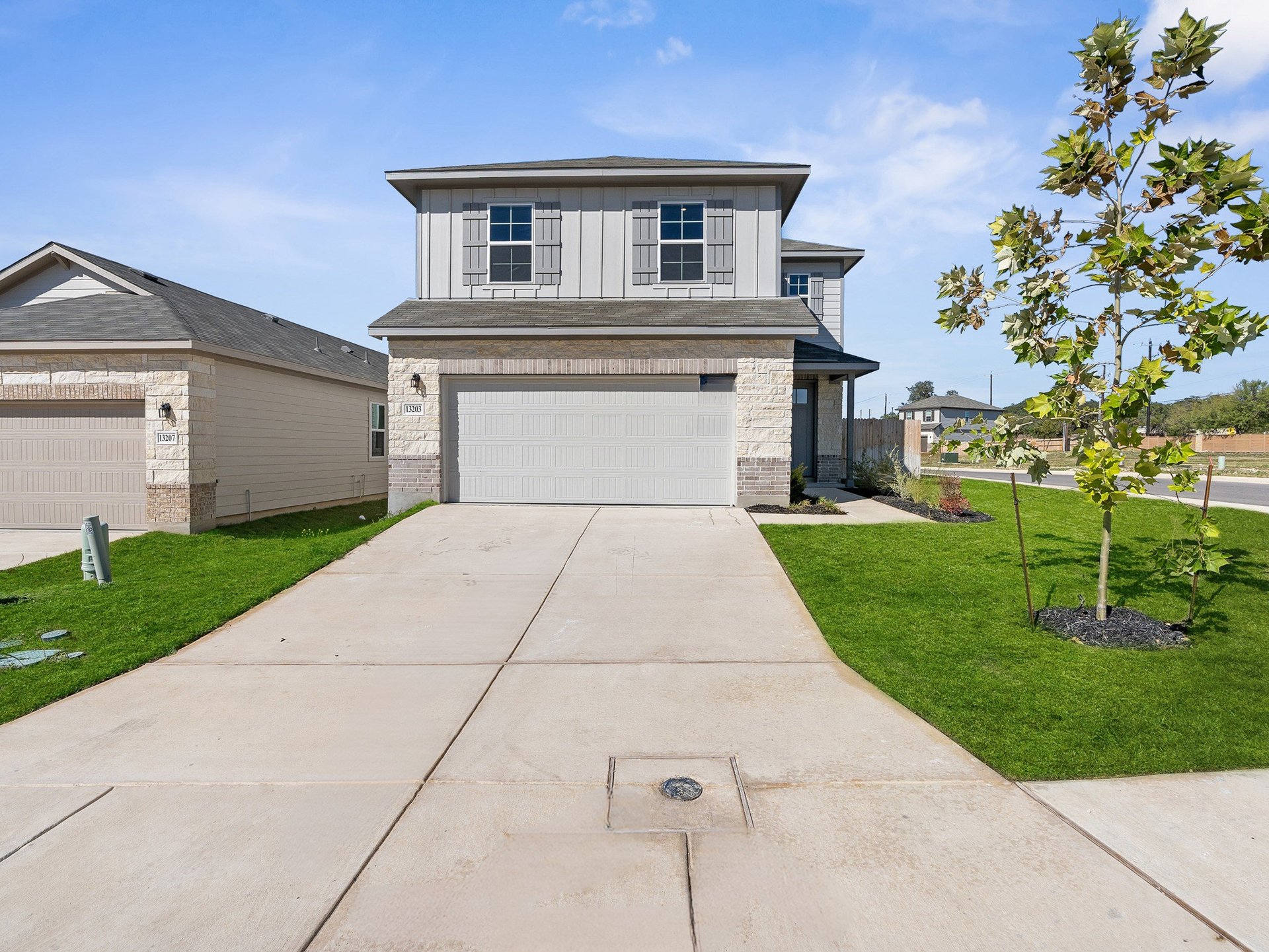 exterior with grass, tree & a garage